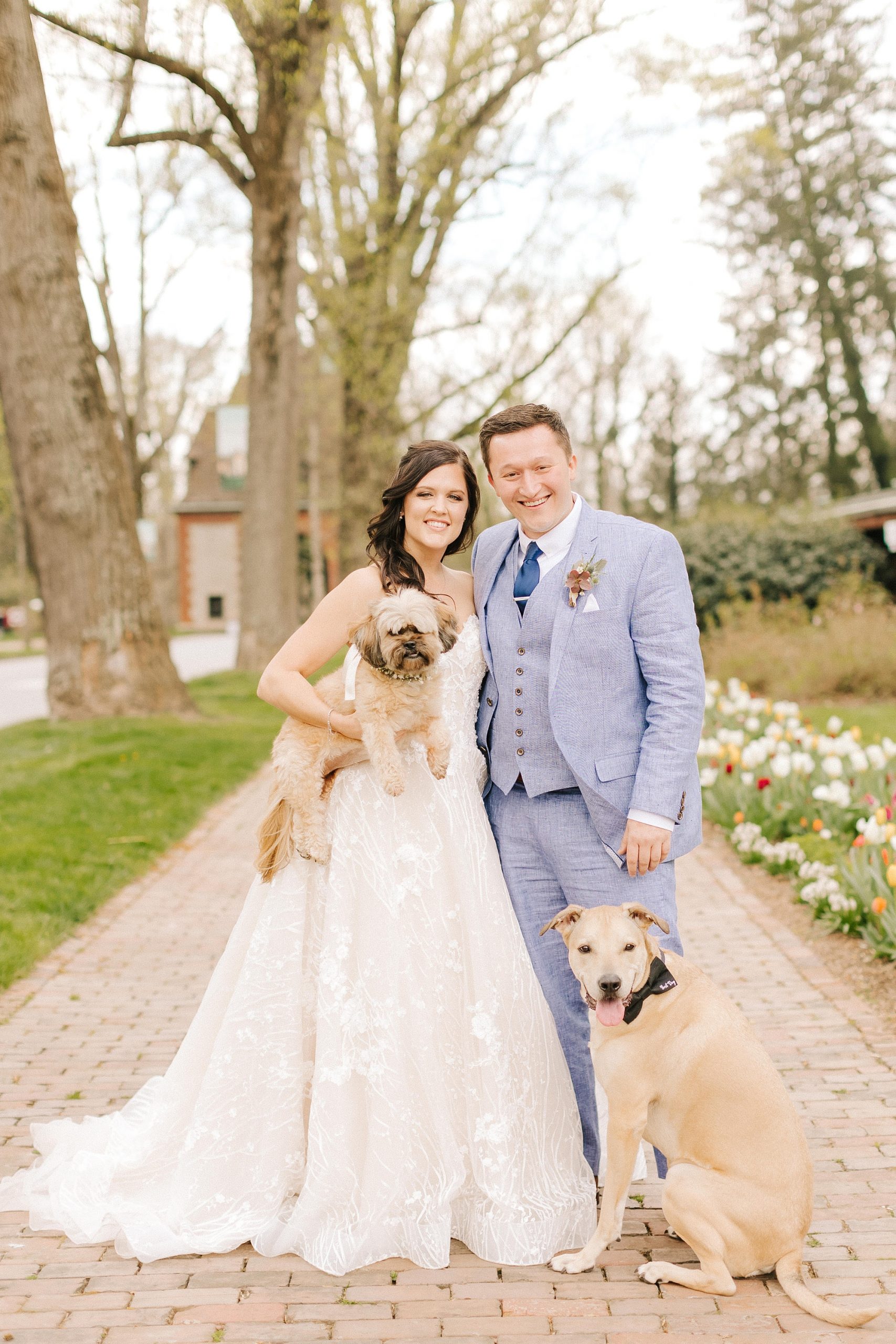 newlyweds hold dog in gardens of NC