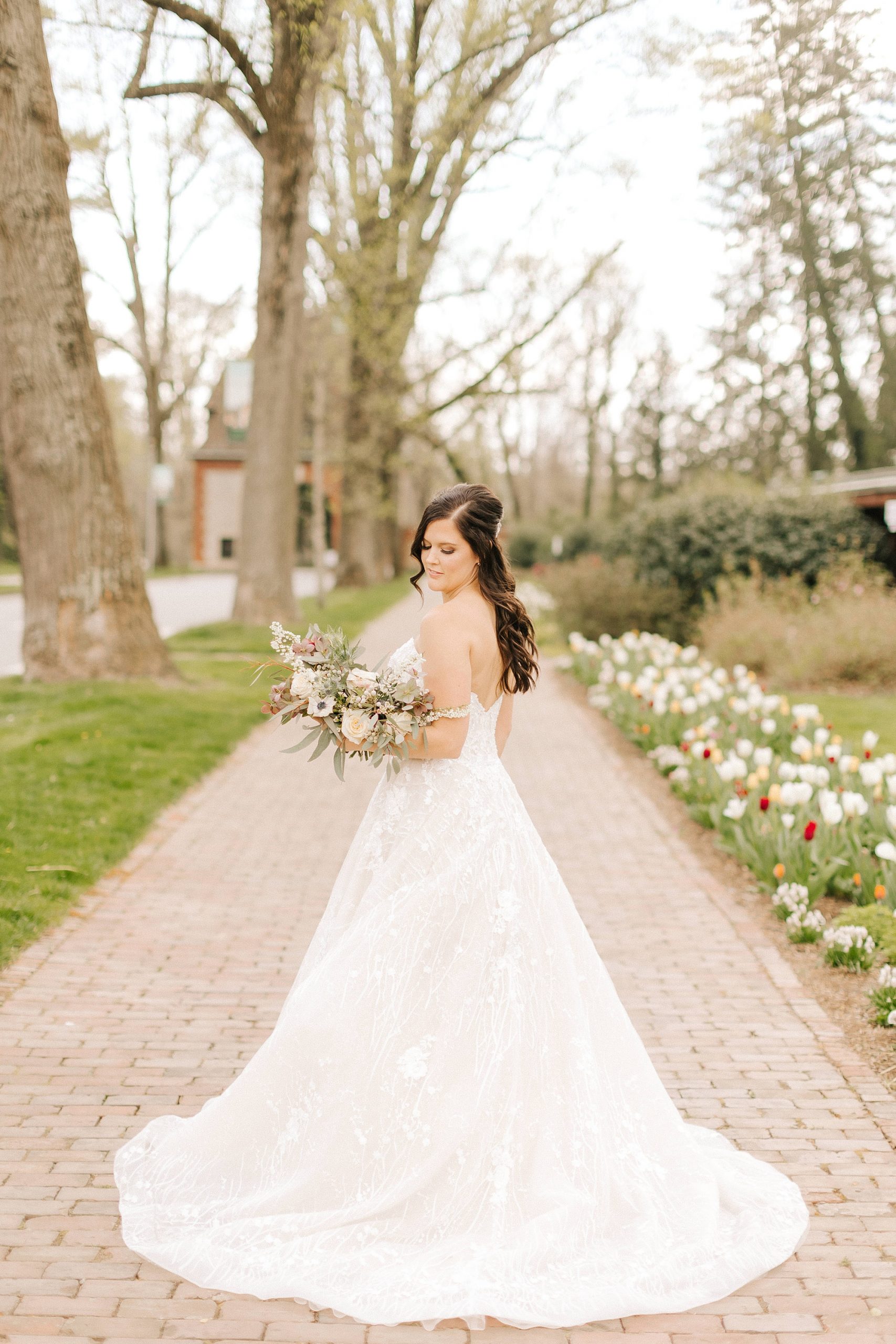 bride holds flowers and looks over shoulder 