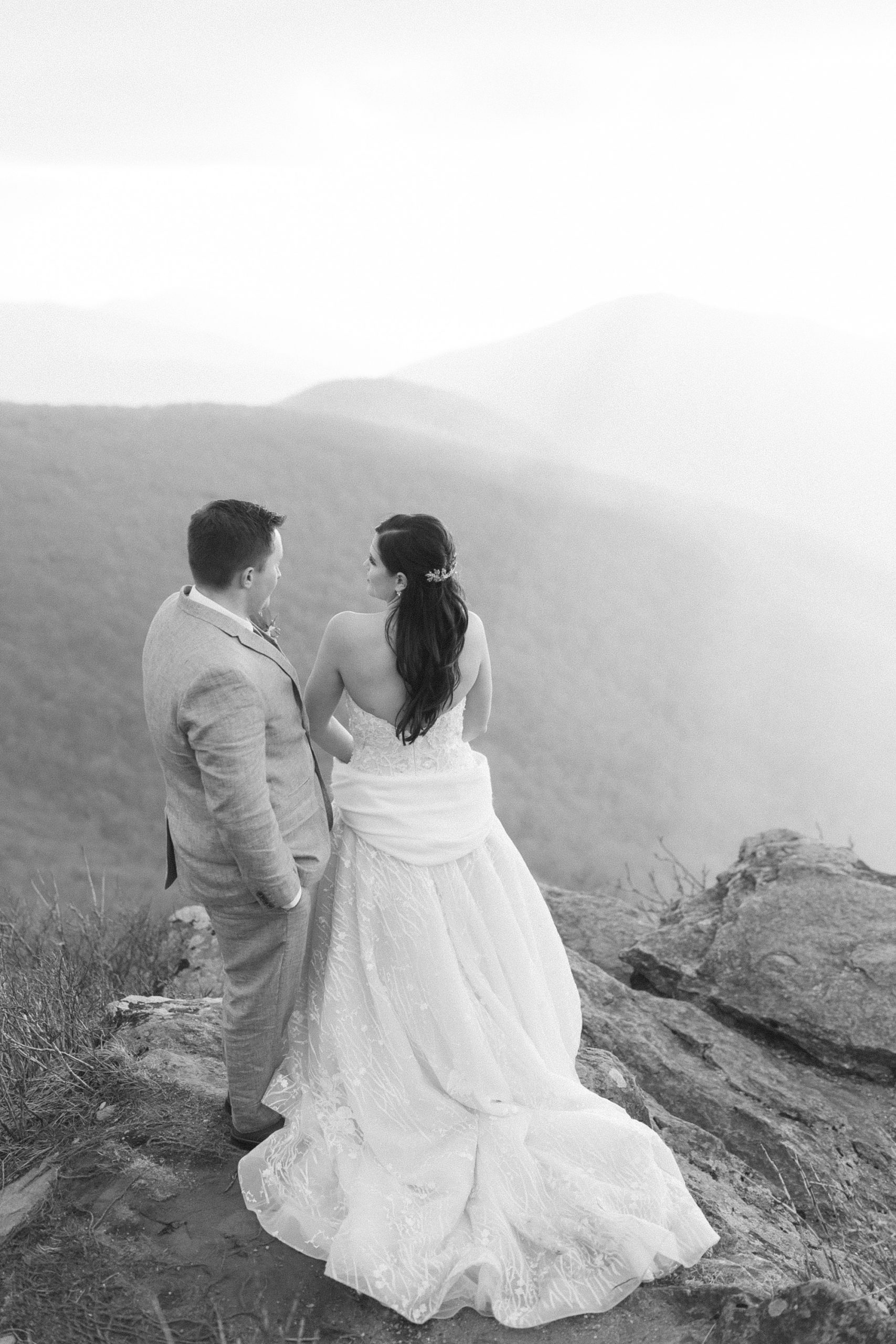 bride and groom stand on Craggy Pinnacle during wedding portraits 