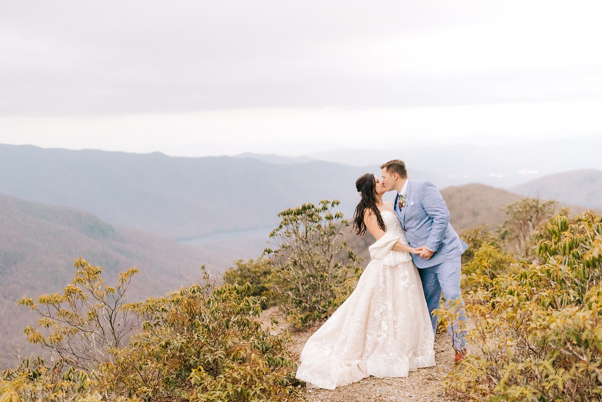 bride and groom kiss on mountaintop in Asheville 
