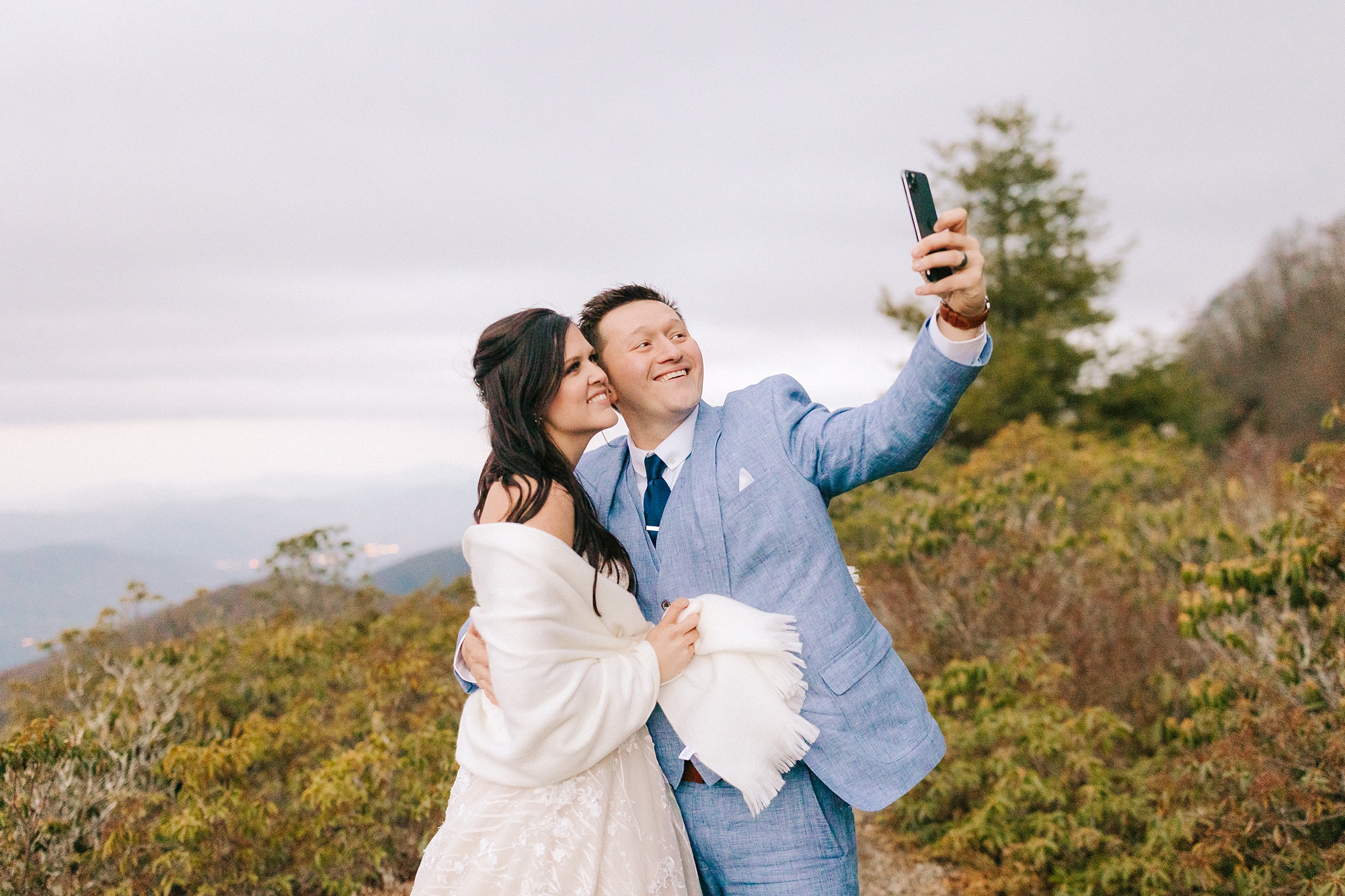 newlyweds take selfie during wedding portraits on Craggy Pinnacle 