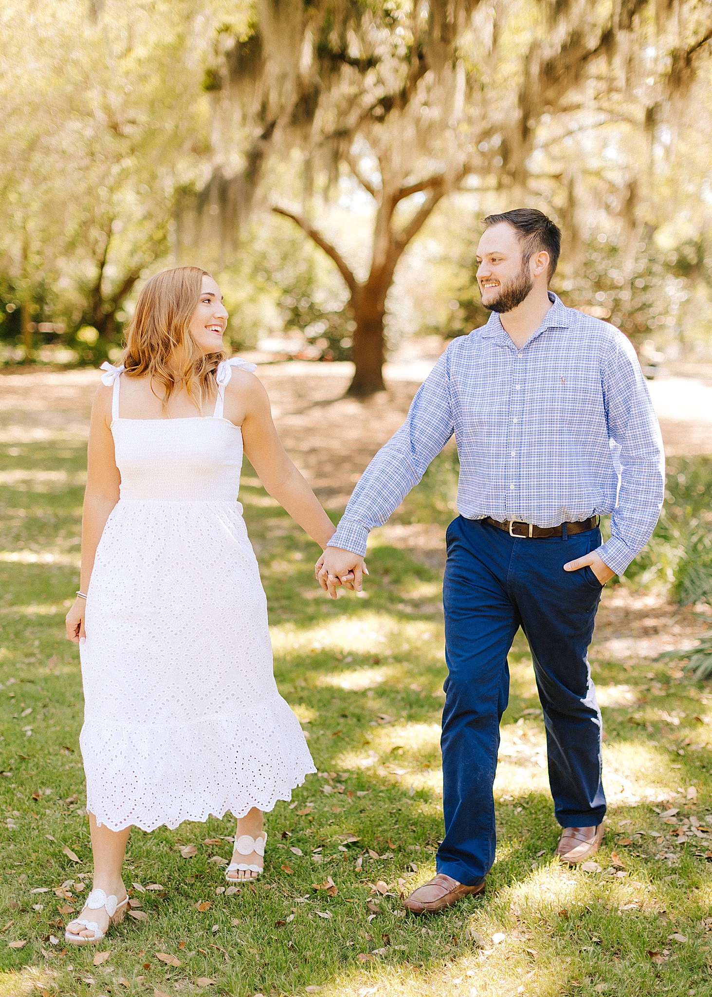 couple holds hands walking during Wilmington engagement session