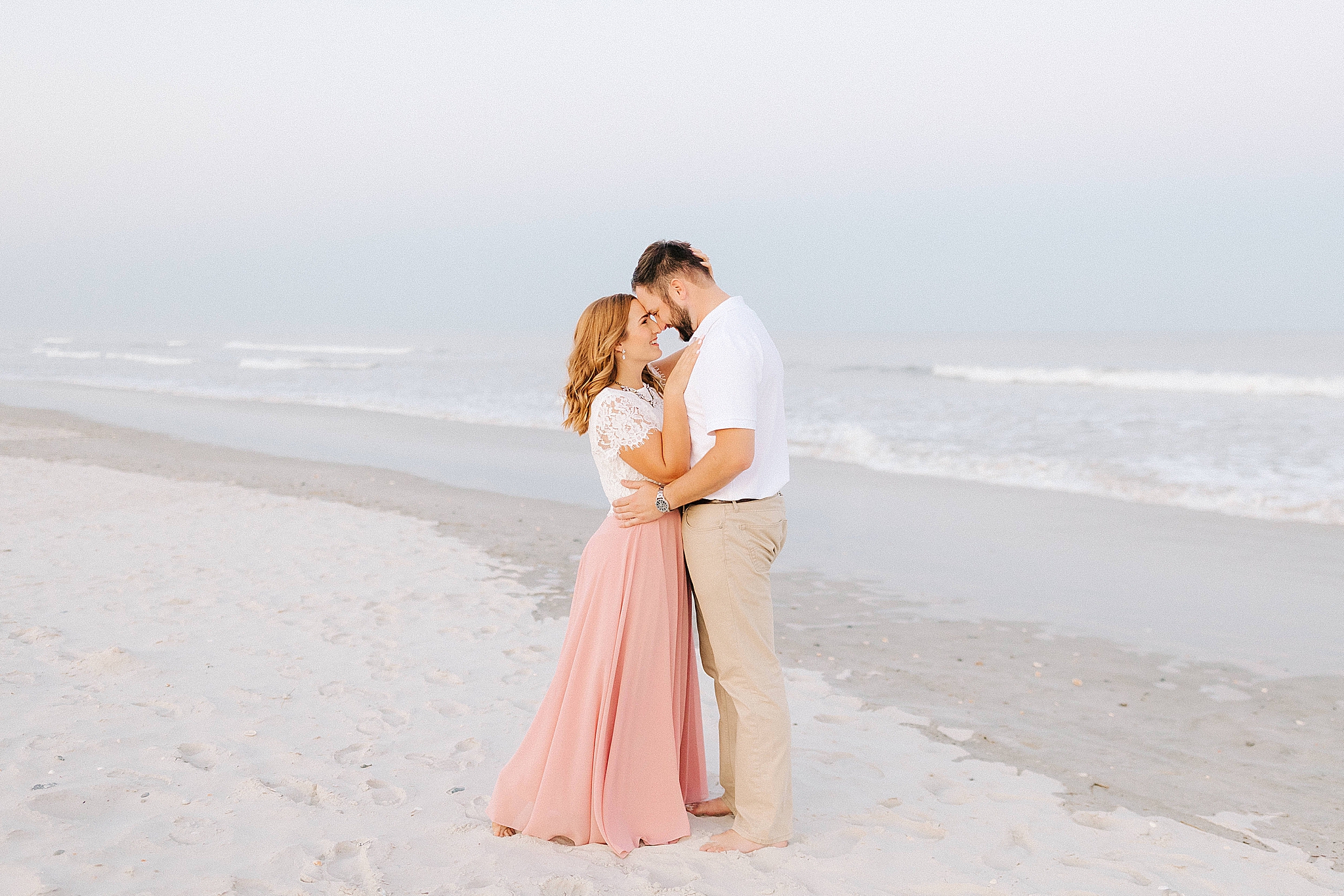 bride and groom hug on beach in Wilmington NC