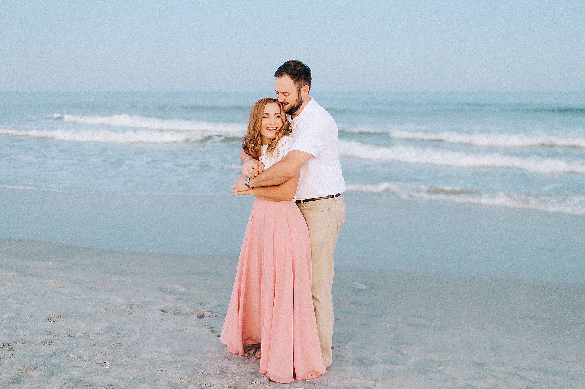 couple hugs on the beach during engagement session