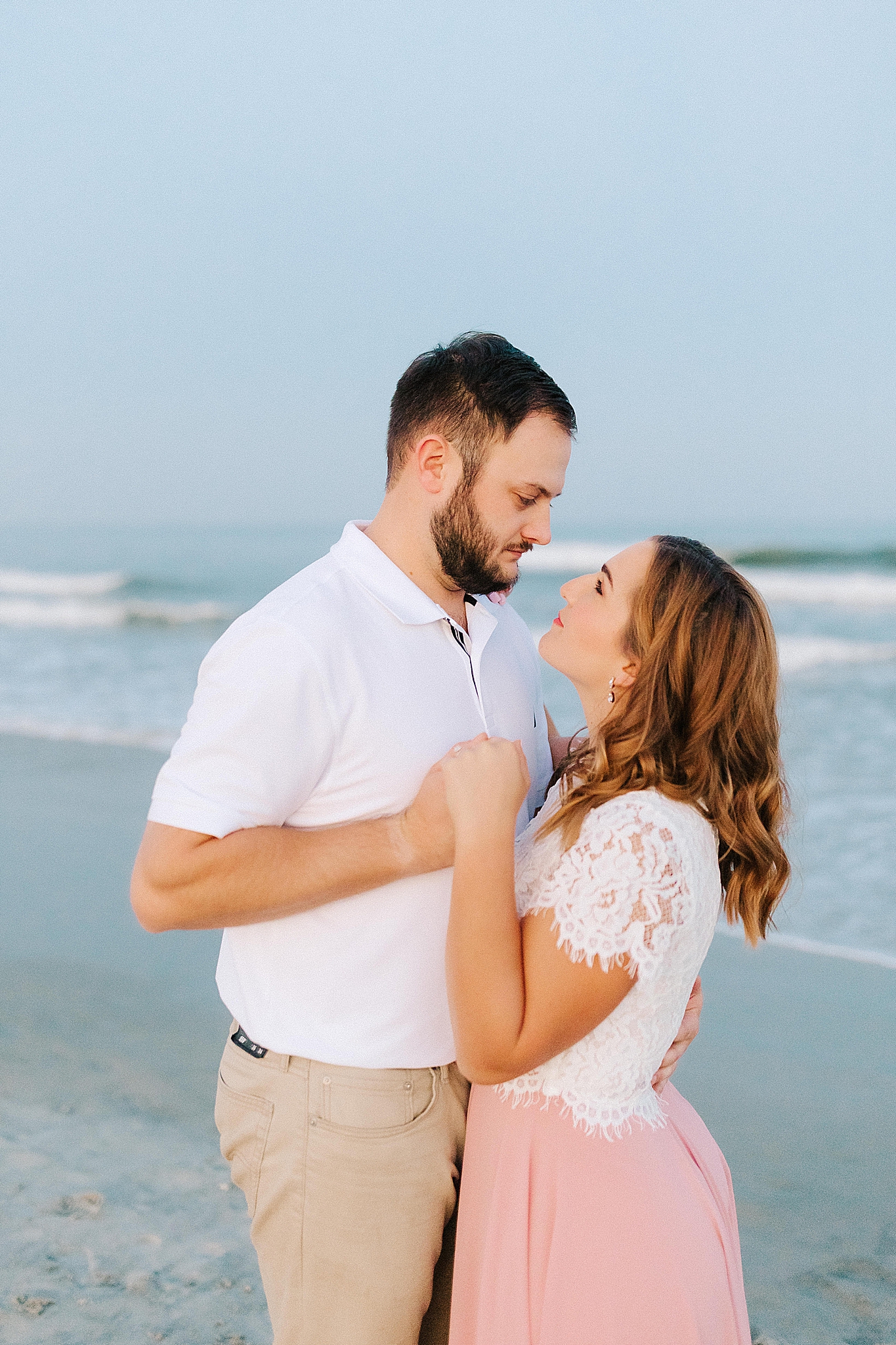 Wilmington engagement session on the beach with bride in white shirt and pink skirt