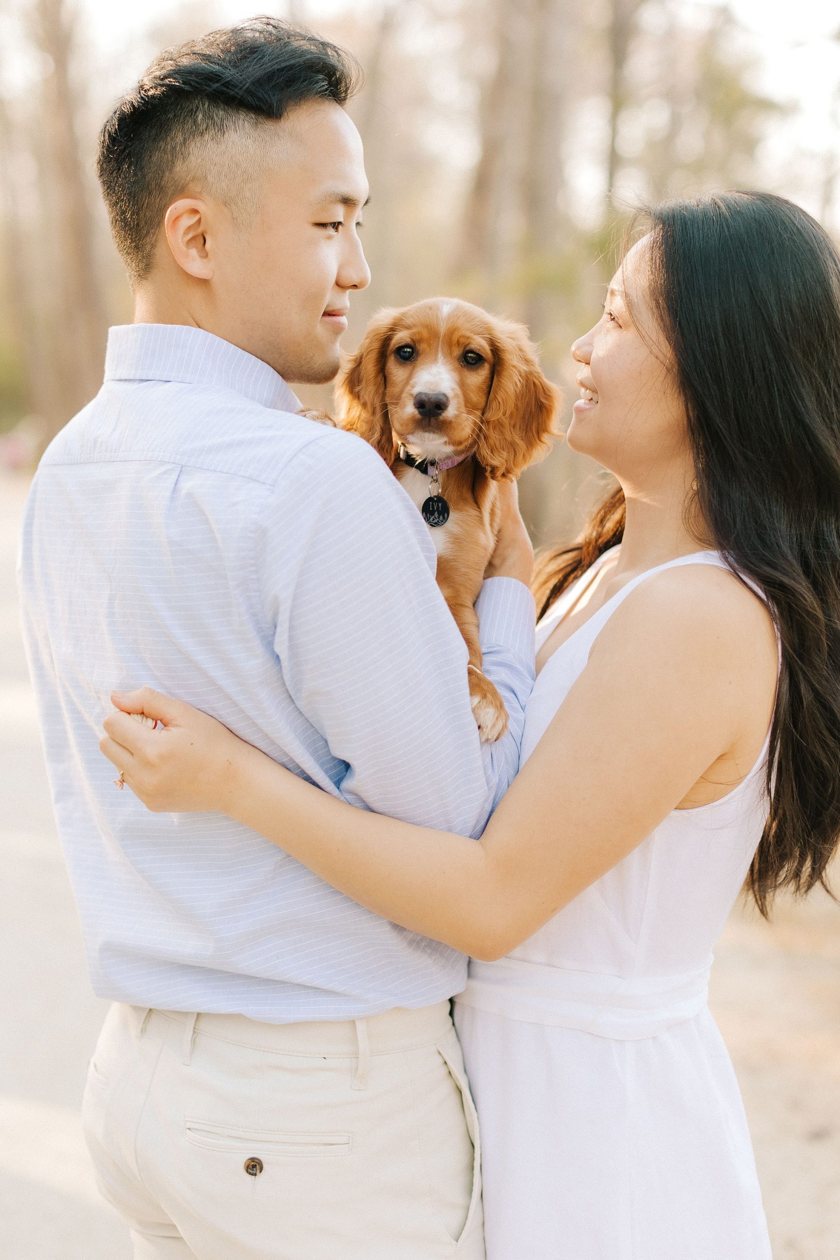 engaged couple holds puppy between them during NC engagement session