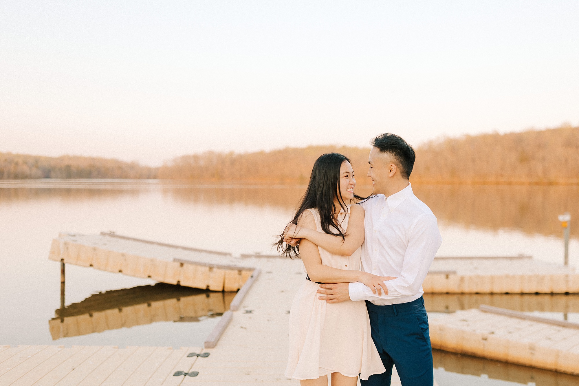 engaged couple sits on docks at Salem Lake