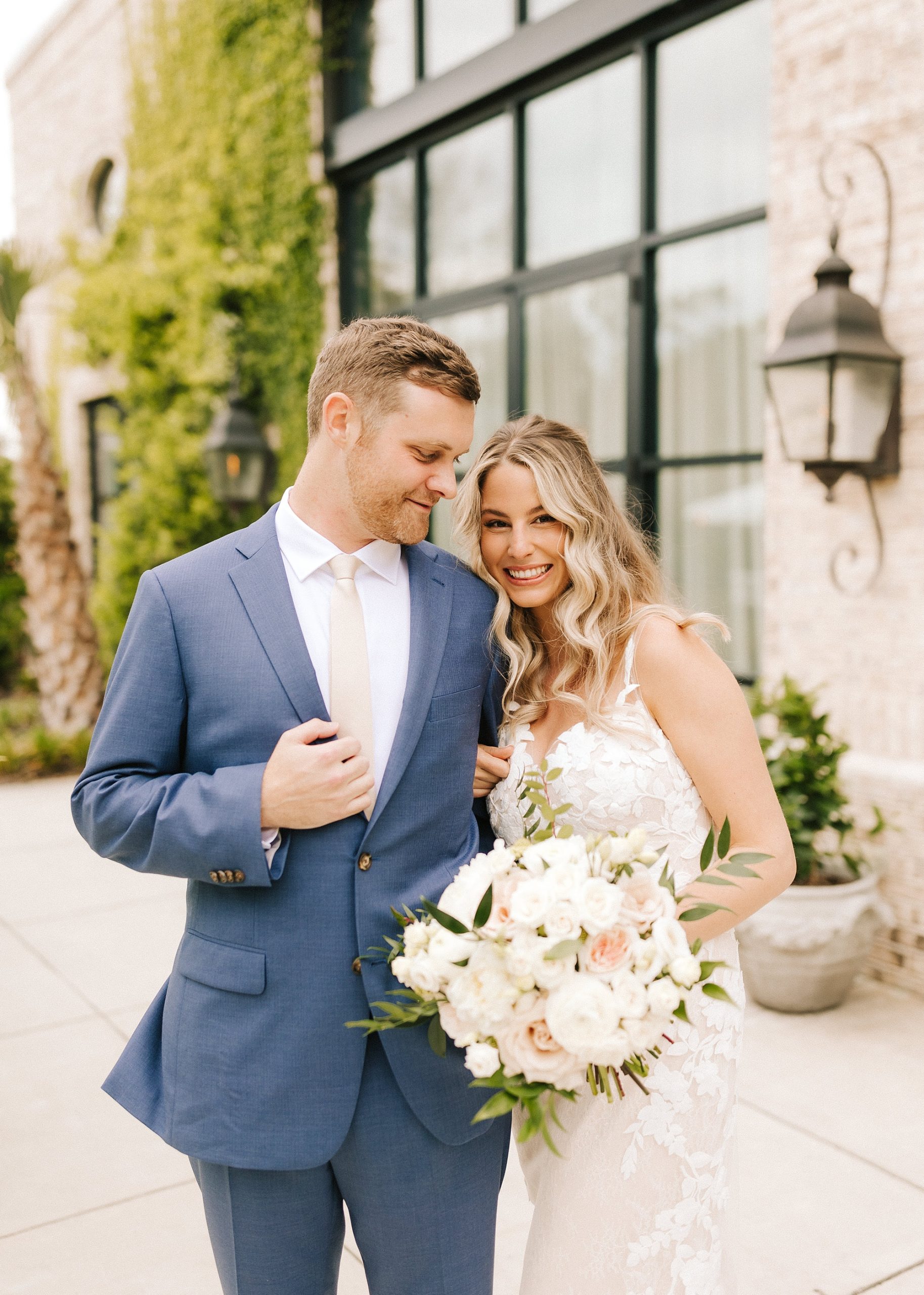 bride leans into groom while he holds lapel of navy suit jacket