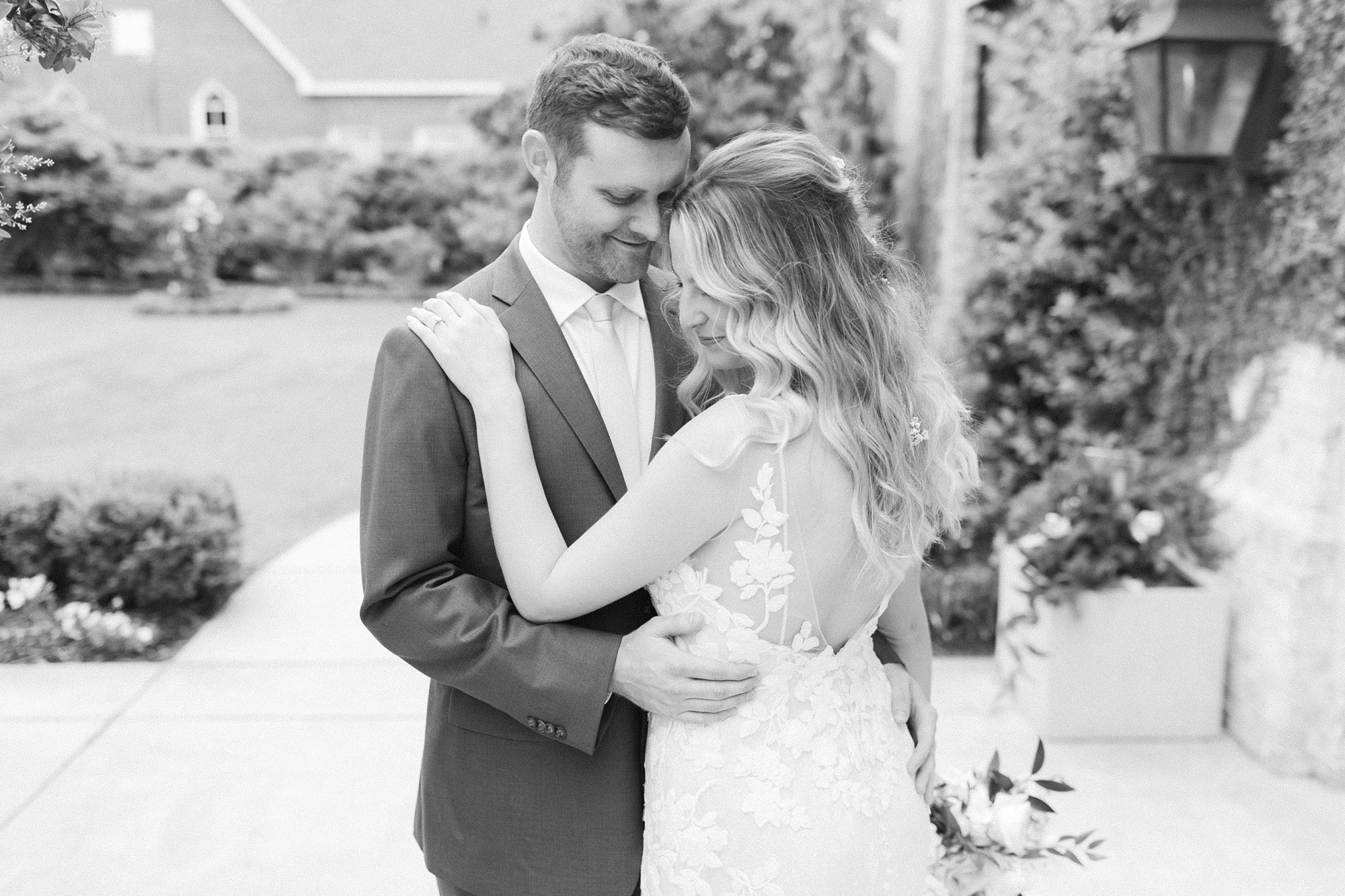 bride and groom hug during spring Wrightsville Manor wedding portraits 