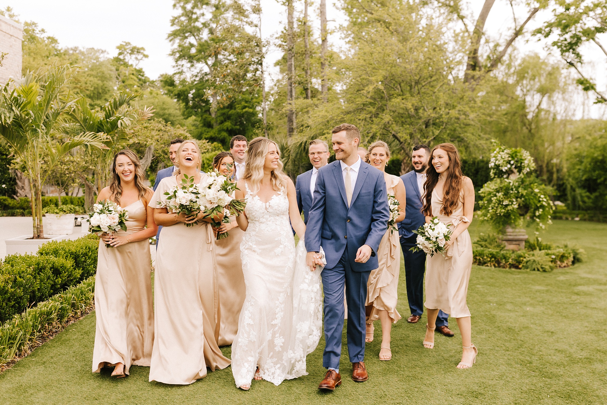 bride and groom walk with bridal party on grounds of Wrightsville Manor