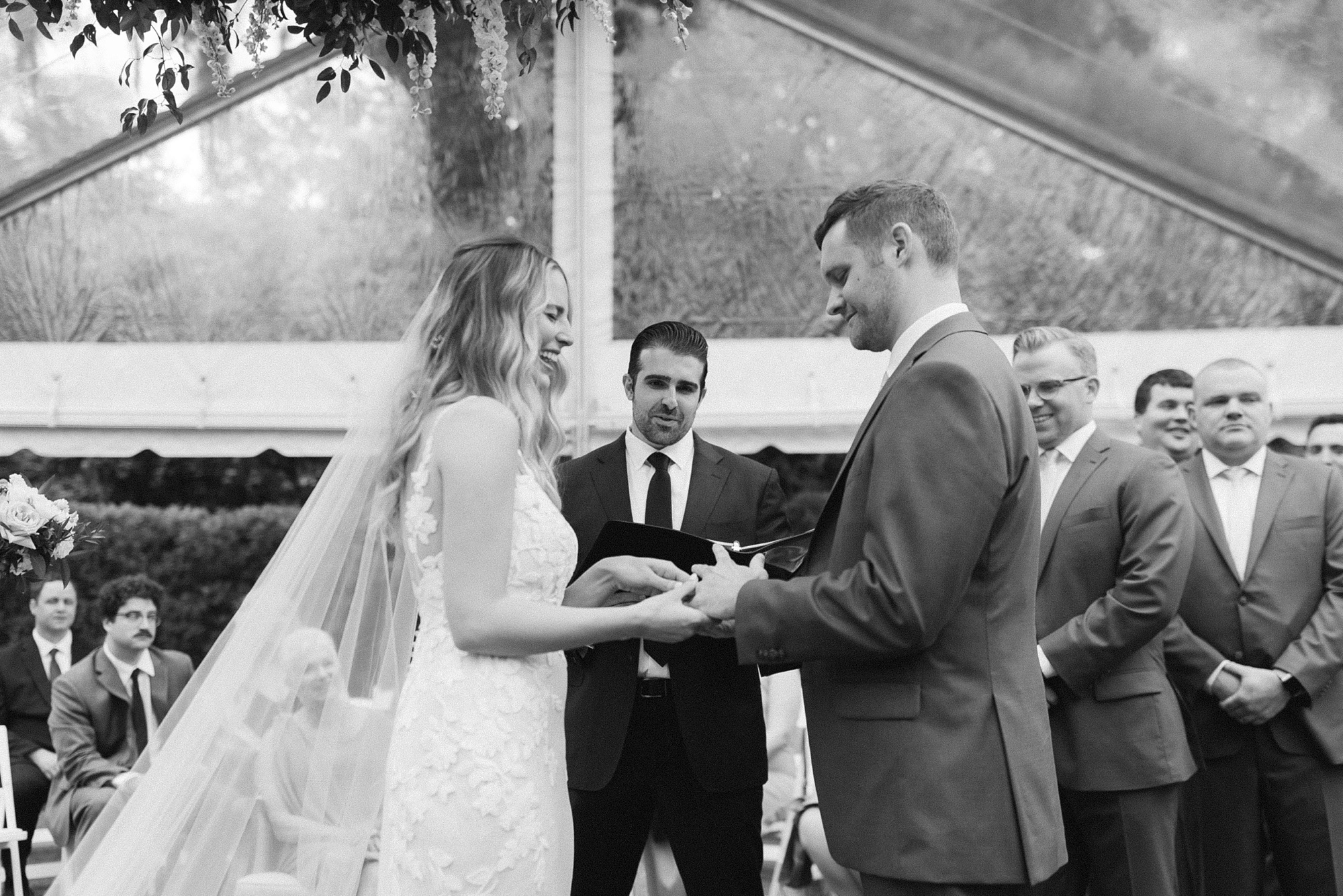 bride and groom exchange rings during spring Wrightsville Manor wedding ceremony 