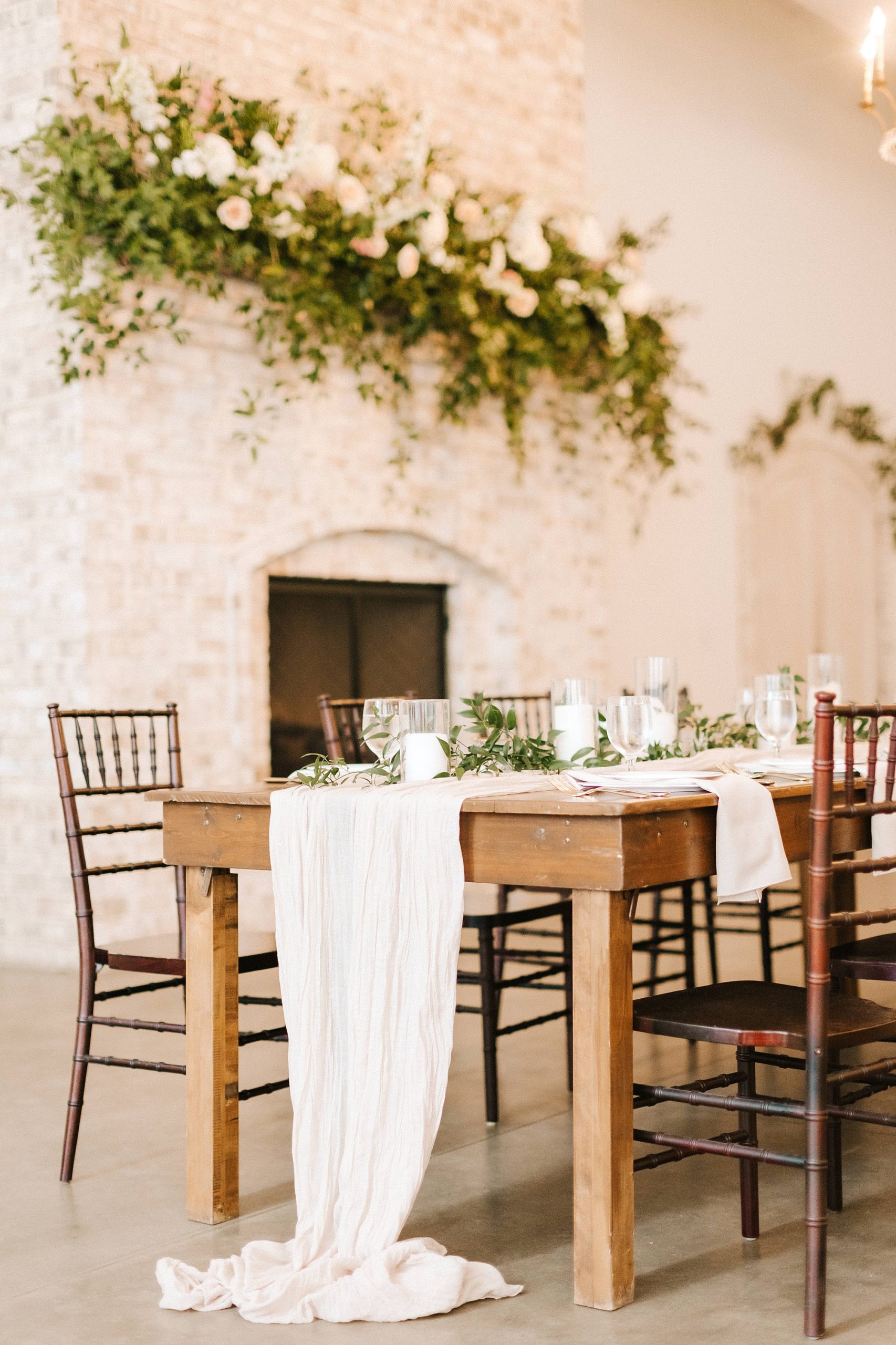 table for spring wedding reception at Wrightsville Manor with table runner and greenery draped on top