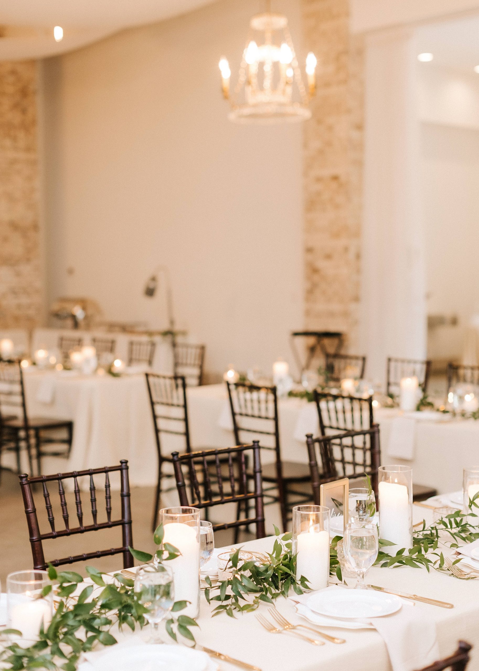 spring wedding reception with greenery table runners and candles 