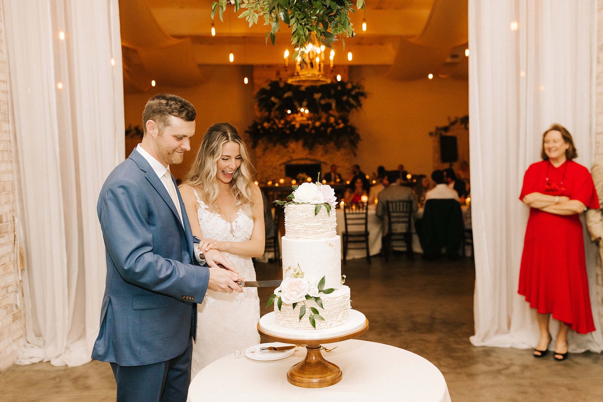 newlyweds cut wedding cake during Wrightsville Manor wedding reception