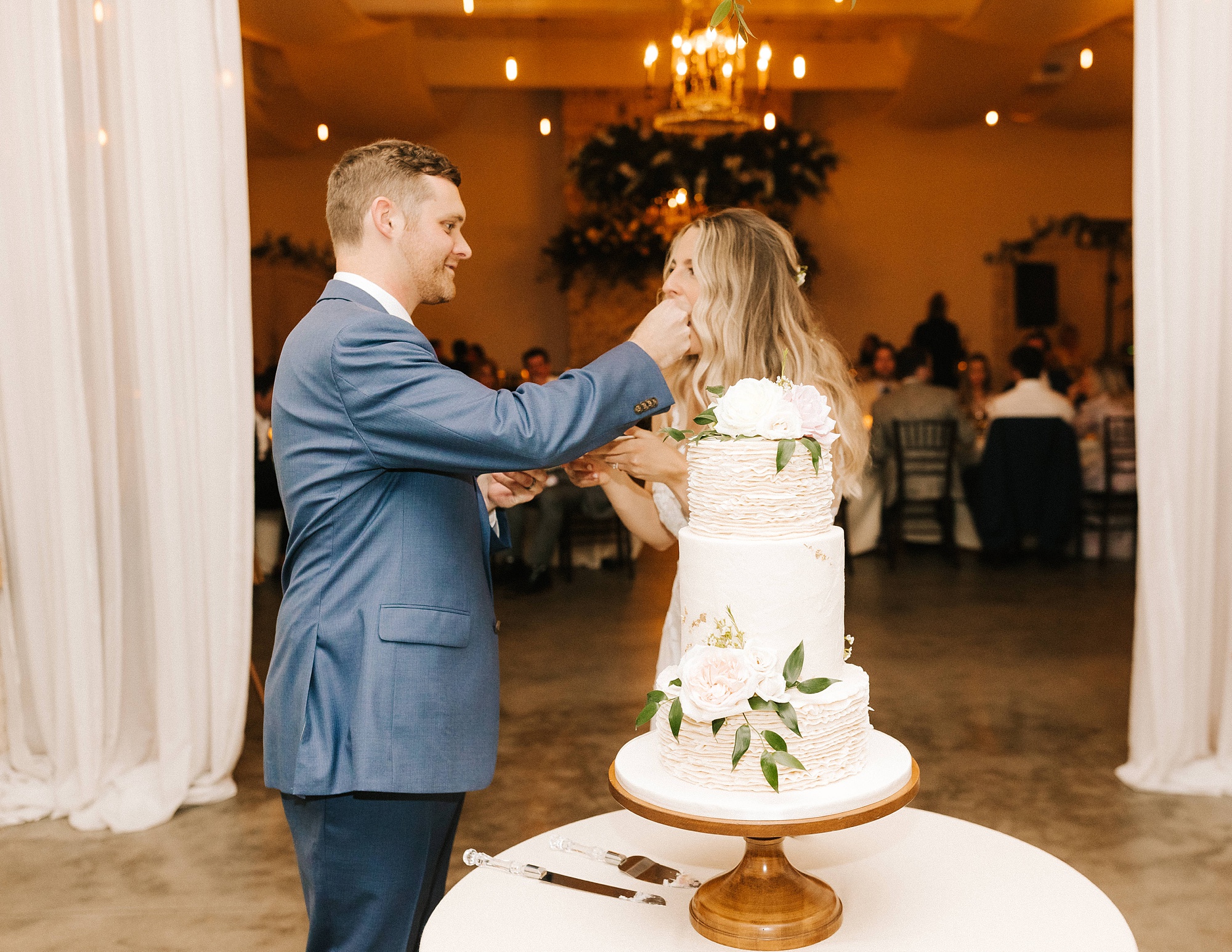 newlyweds cut wedding cake during Wrightsville Manor wedding reception