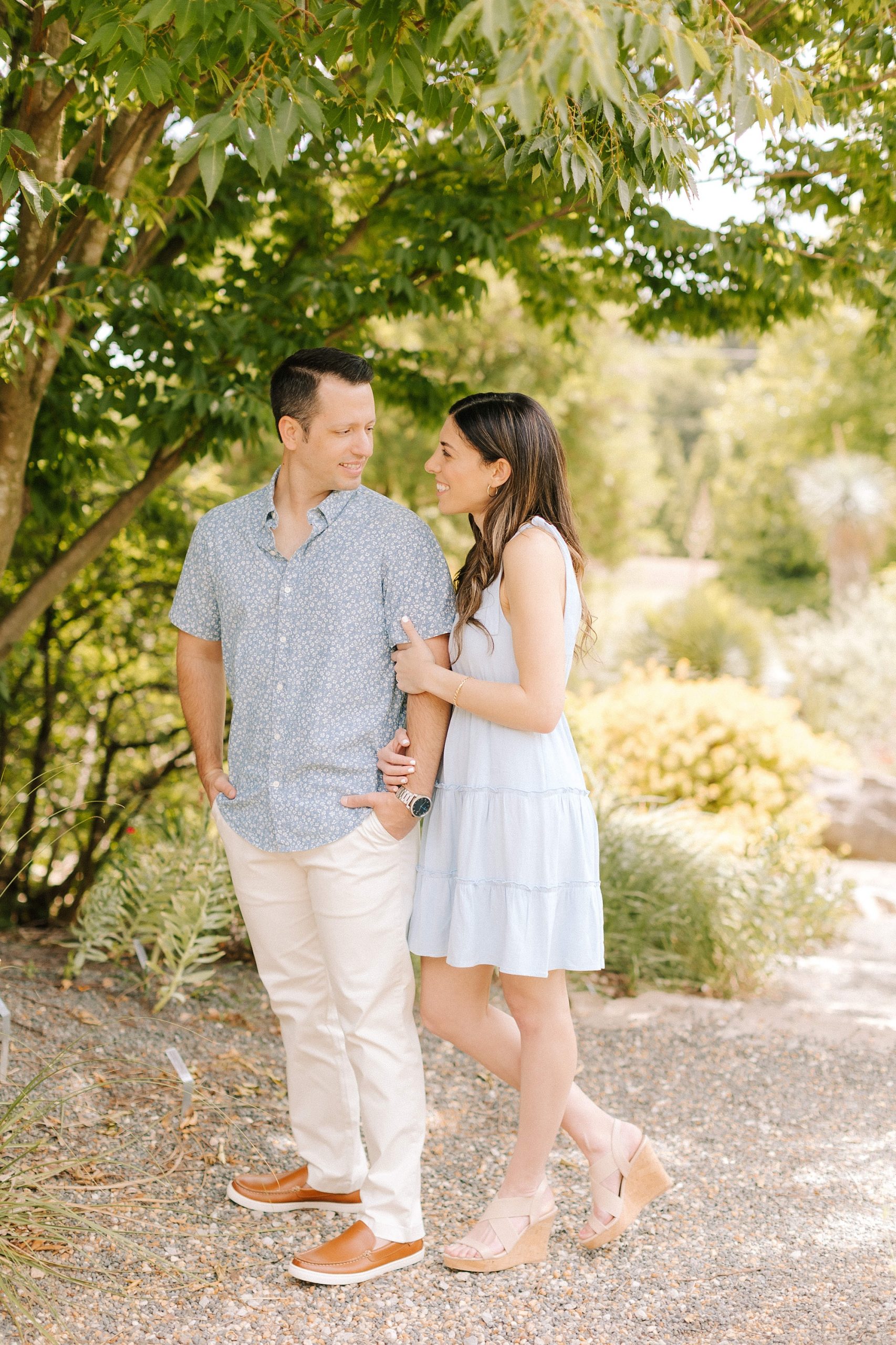 brie and groom pose in garden during JC Raulston Arboretum engagement photos
