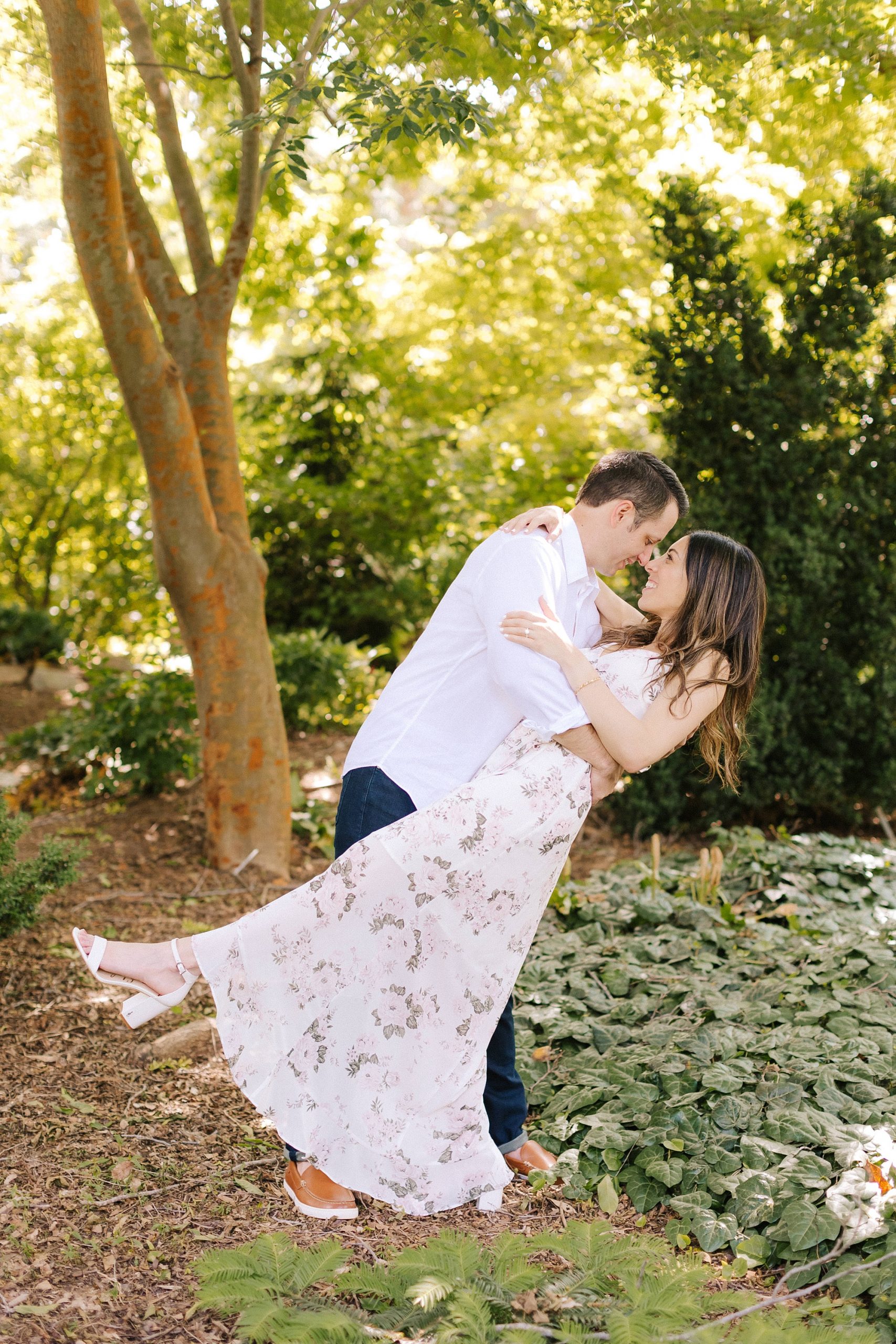 groom dips bride backwards during Raleigh NC engagement session 