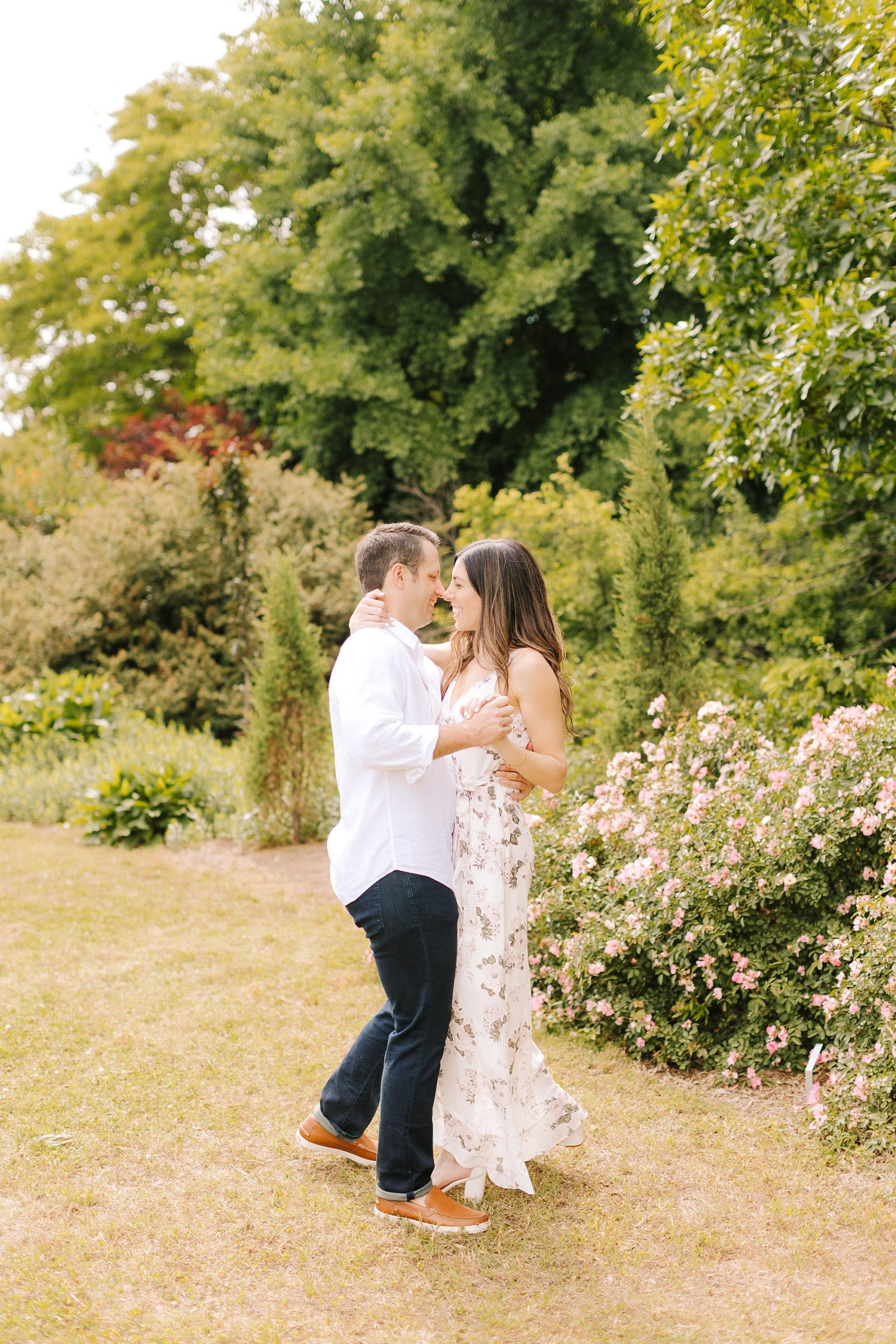 couple dances in gardens during Raleigh NC engagement photos 