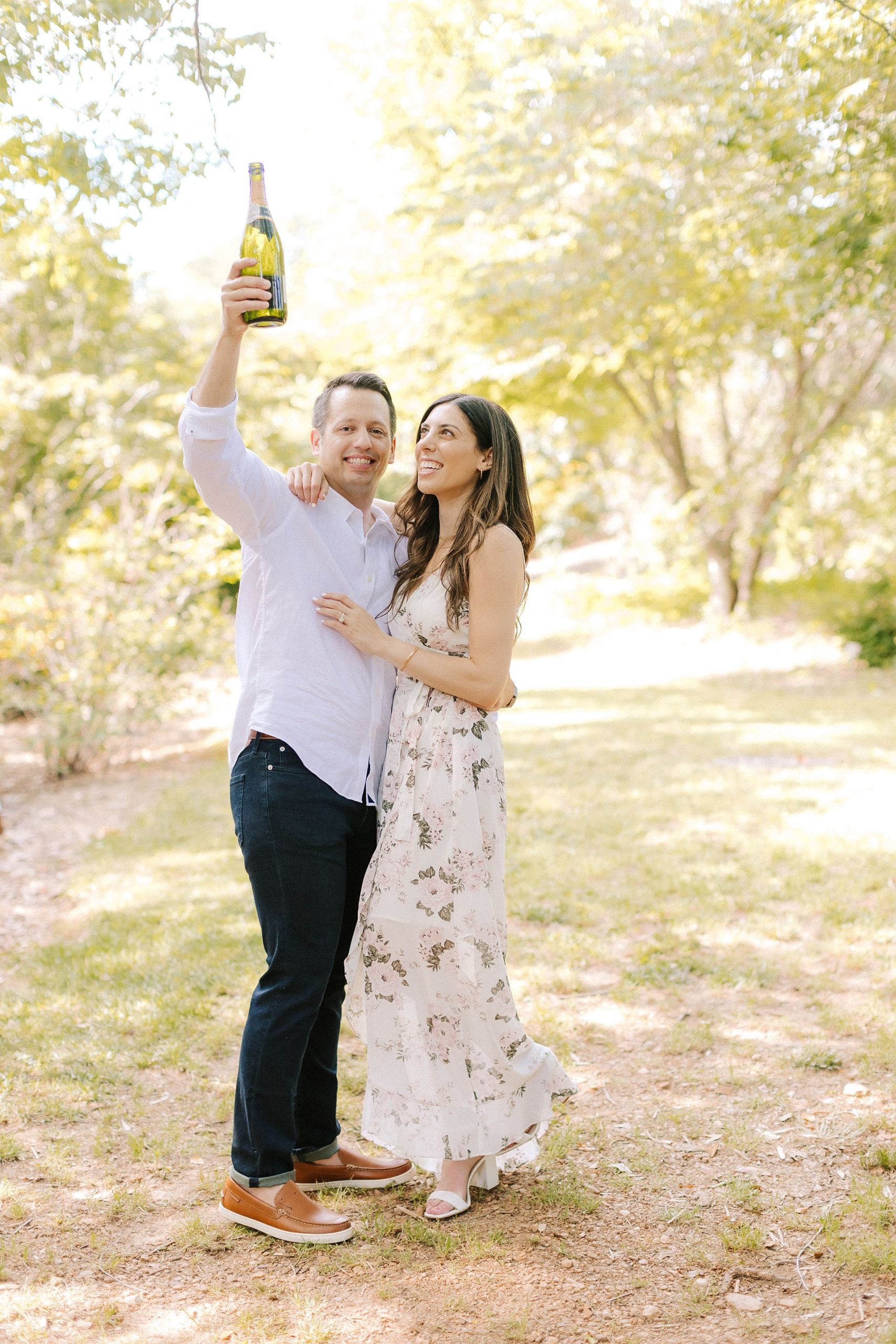 groom lifts champagne in the air during NC engagement photos 