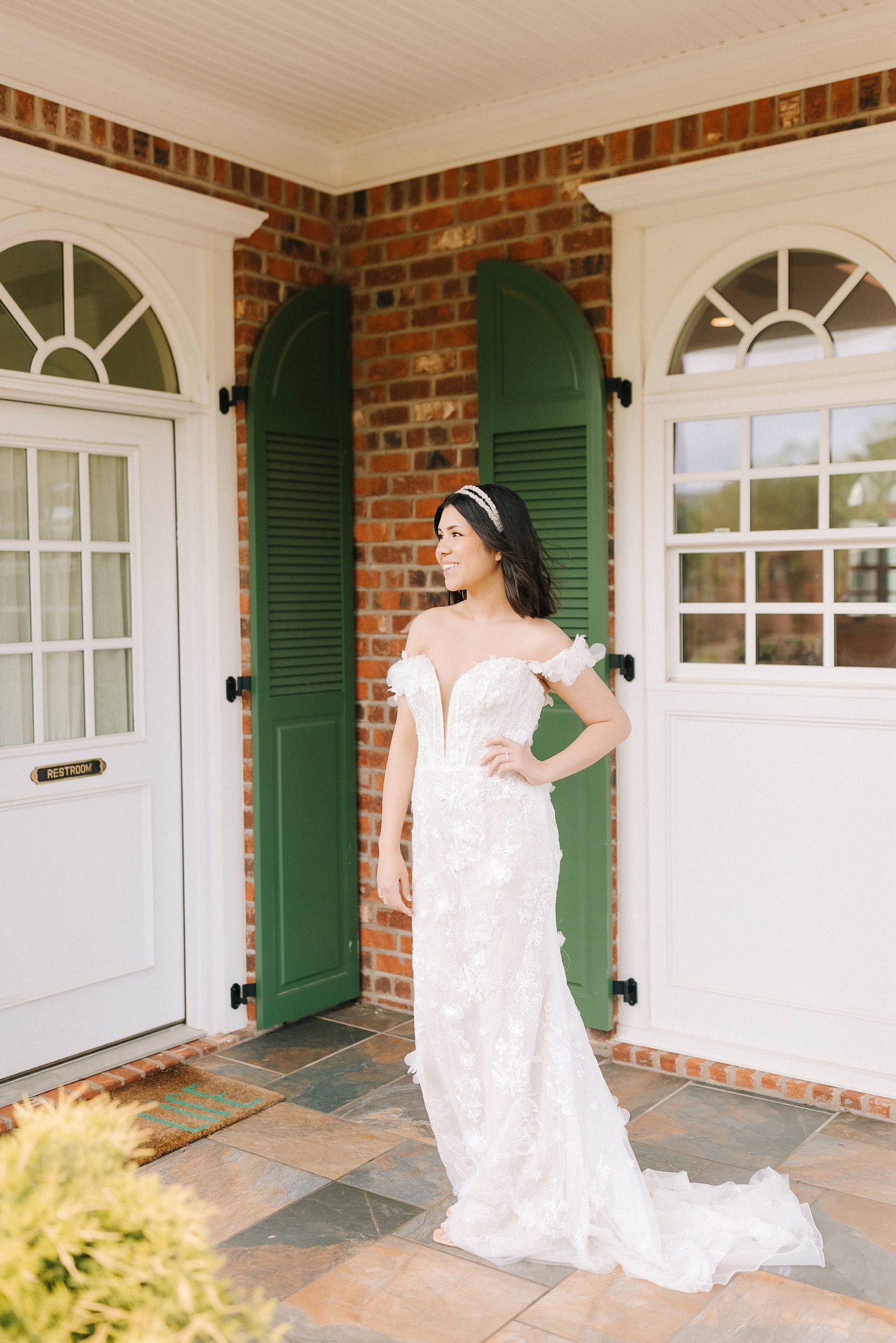 bride in wedding dress smiles on front porch of Moore's Spring Manor