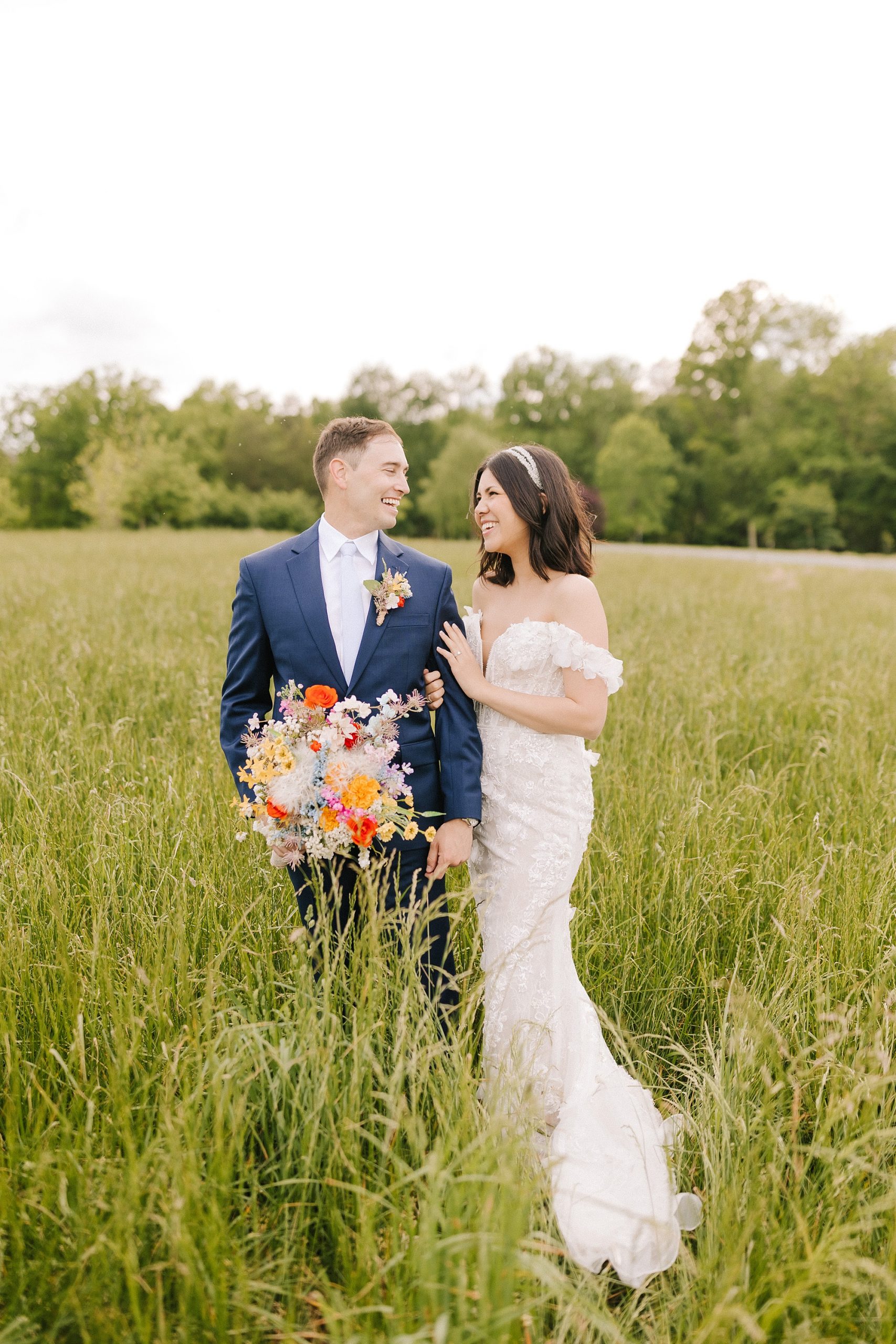 bride and groom stand together in tall fields