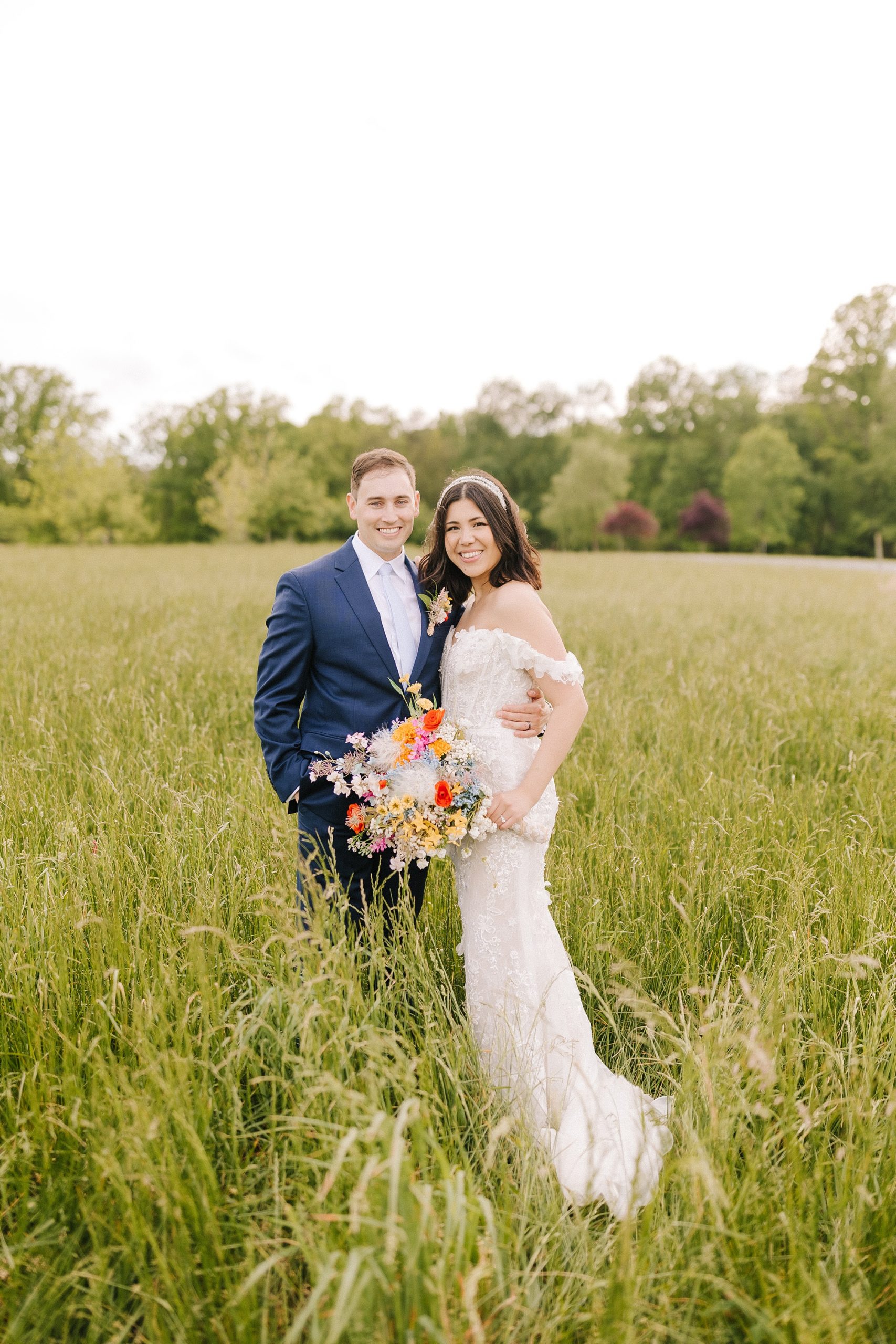 bride and groom stand together in field during Moore's Spring Manor elopement