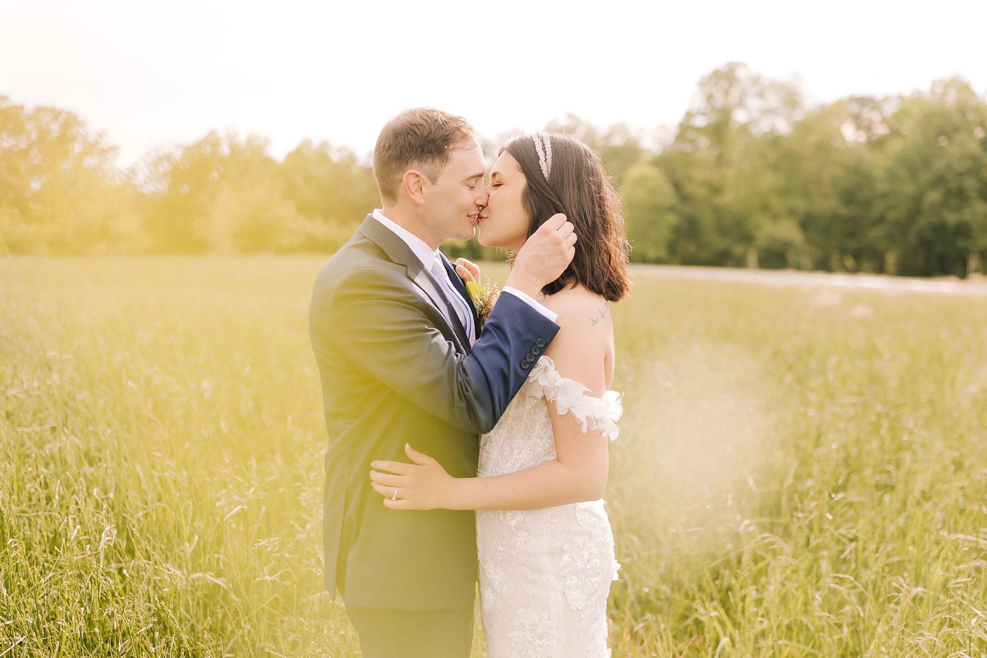 bride and groom kiss in field during Moore's Spring Manor elopement