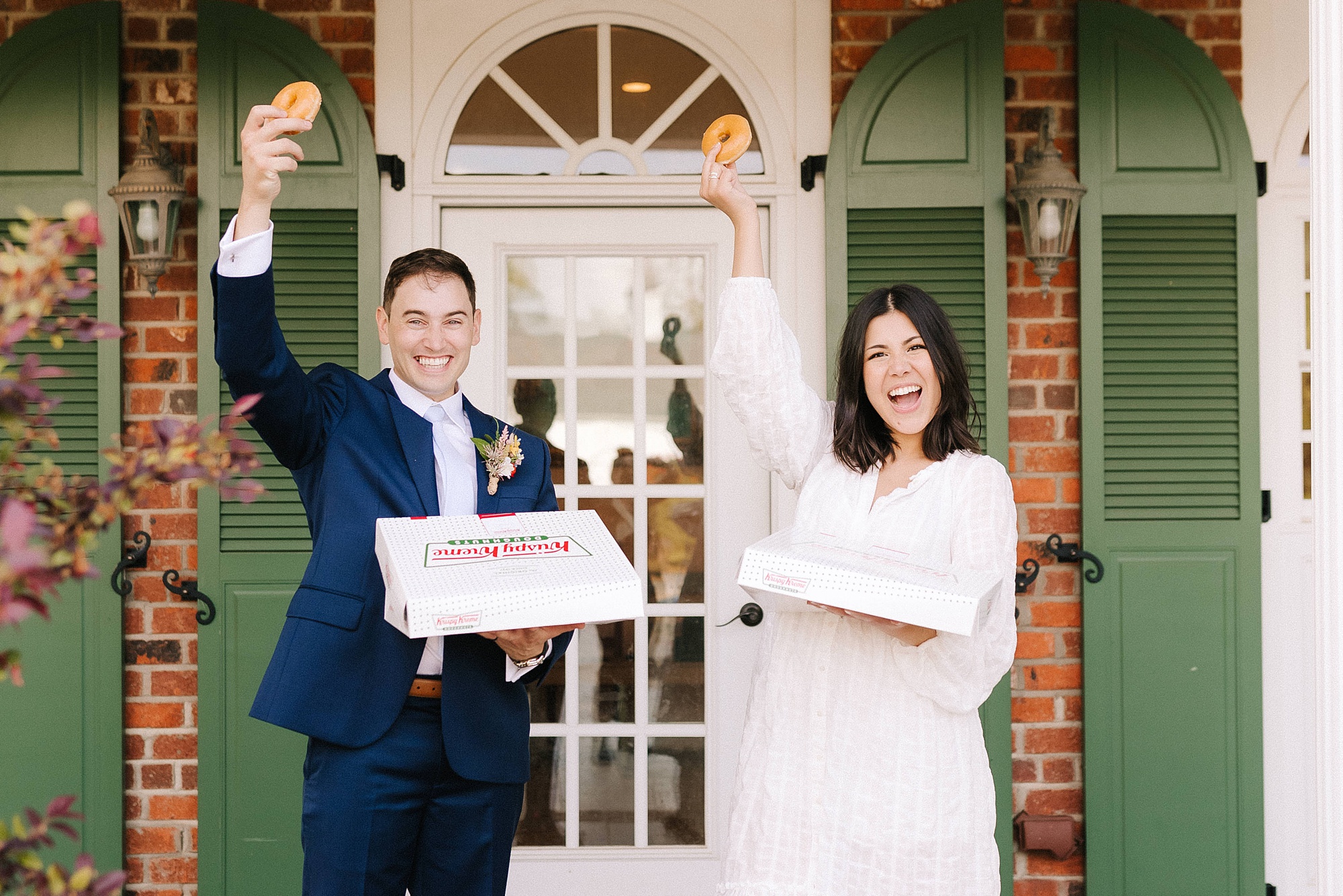 bride and groom hold up donut from Krispy Kreme 