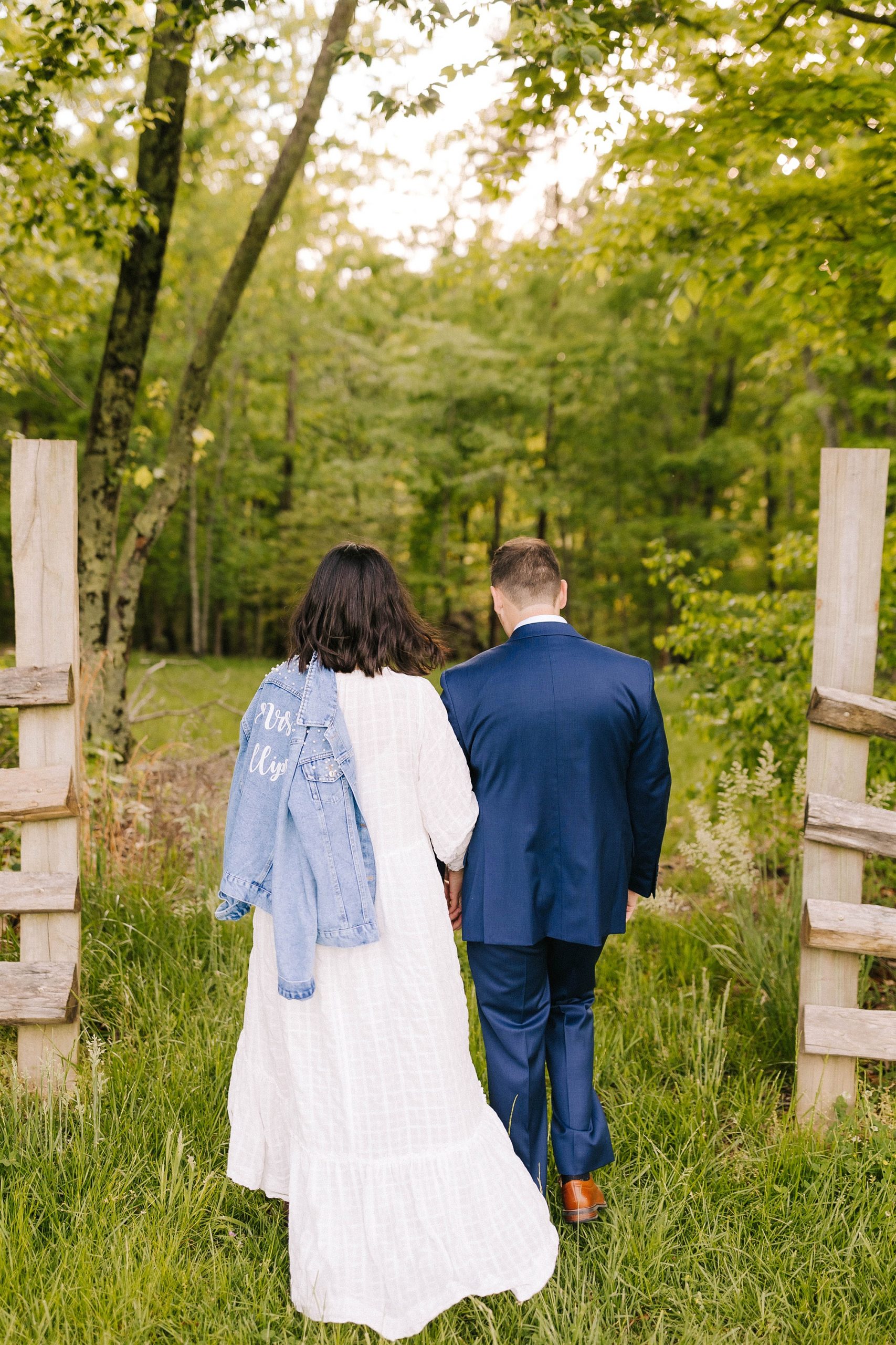 married couple walks through wooden gates after Moore's Spring Manor elopement