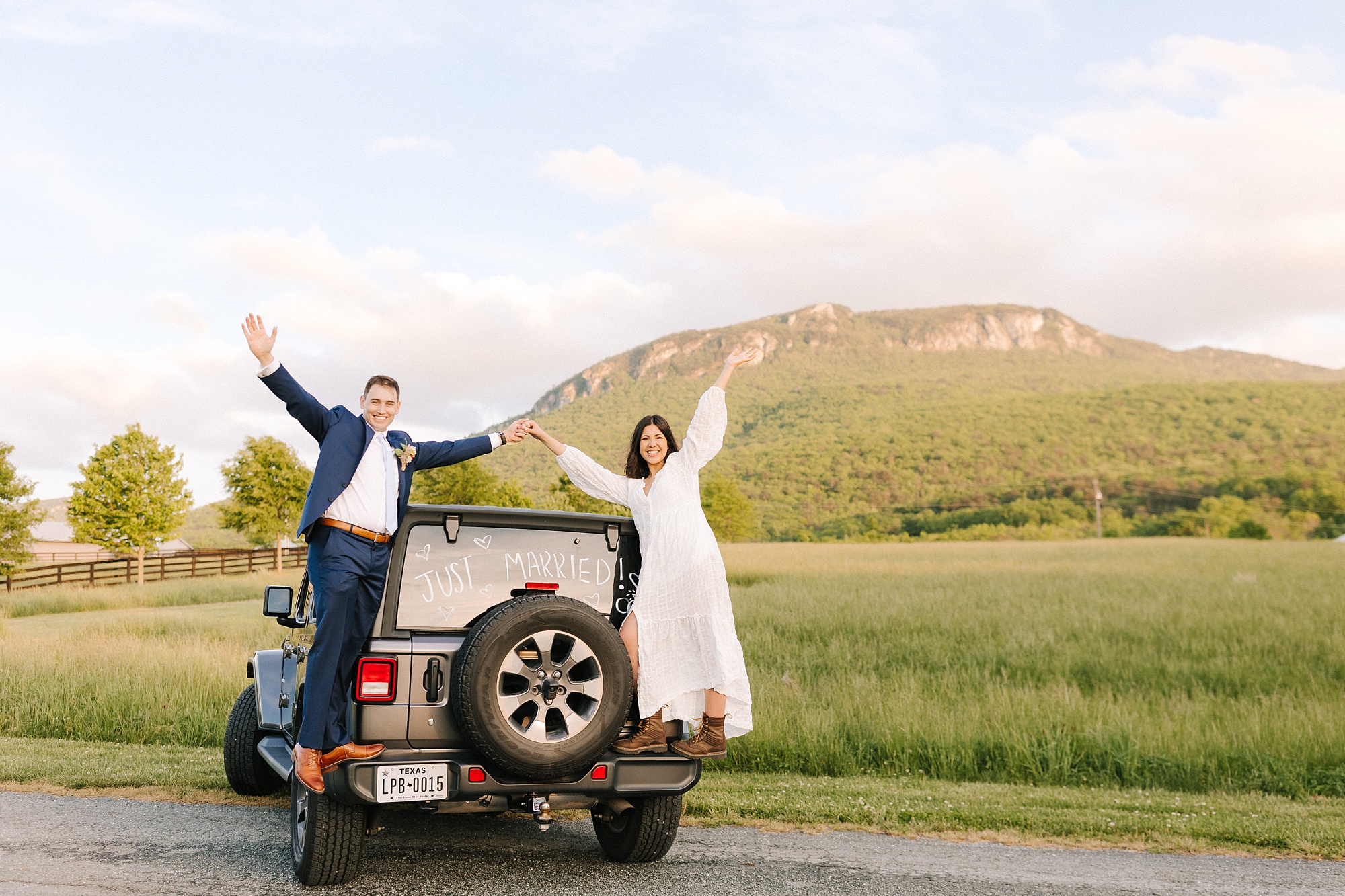 married couple stands on back of jeep after Moore's Spring Manor elopement