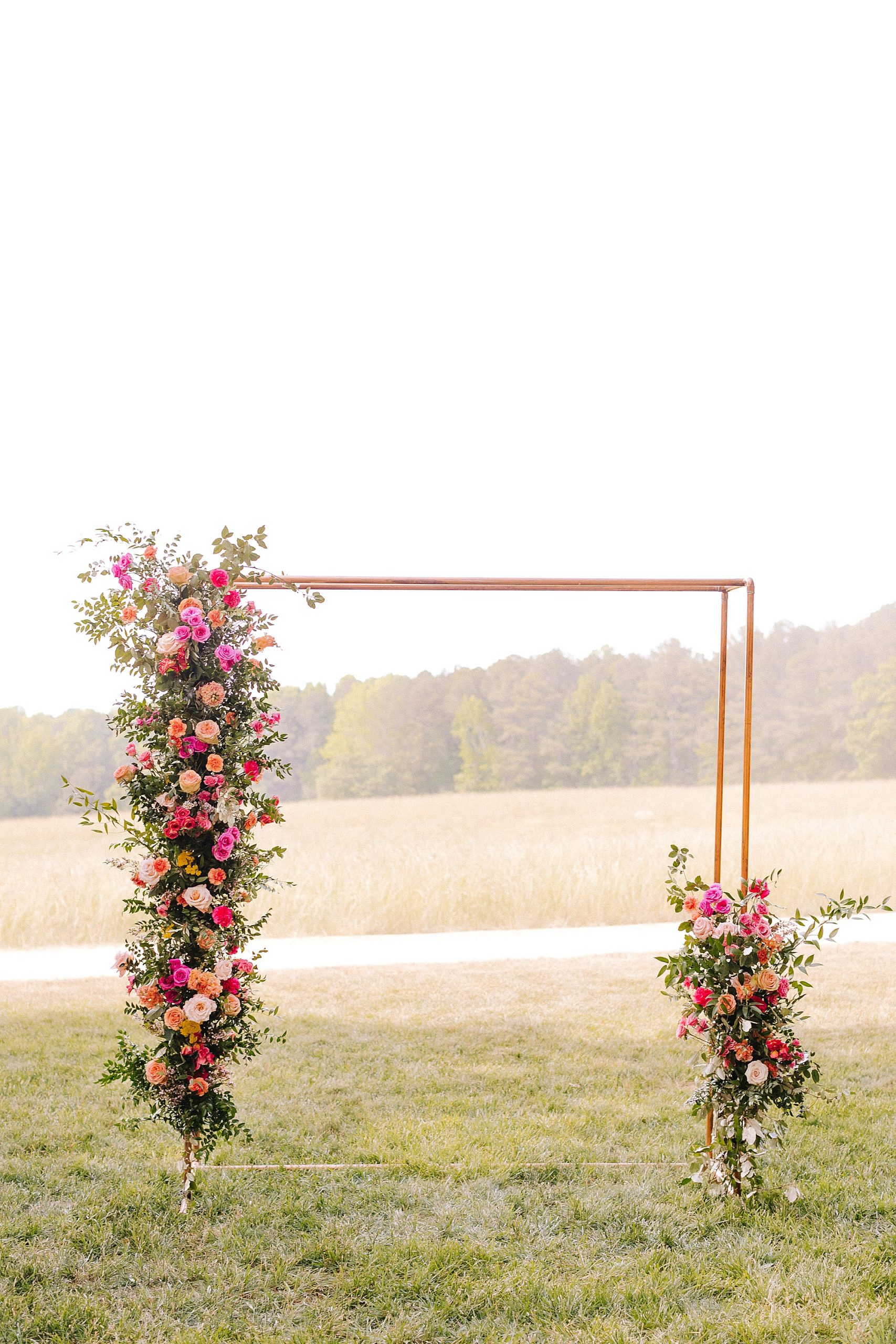 outdoor wedding ceremony arbor with copper and bright floral details 