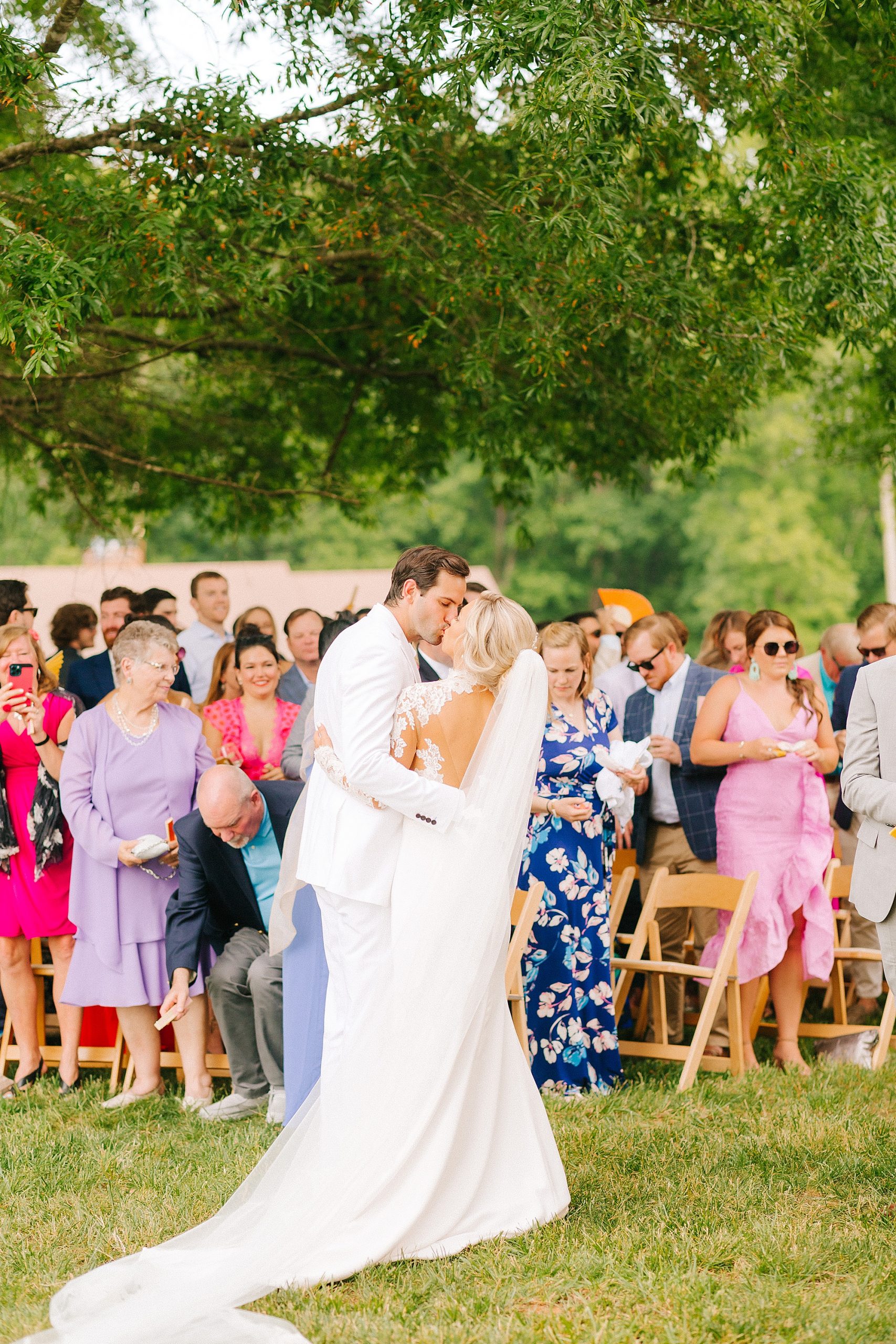 bride and groom kiss during ceremony at The Meadows Raleigh