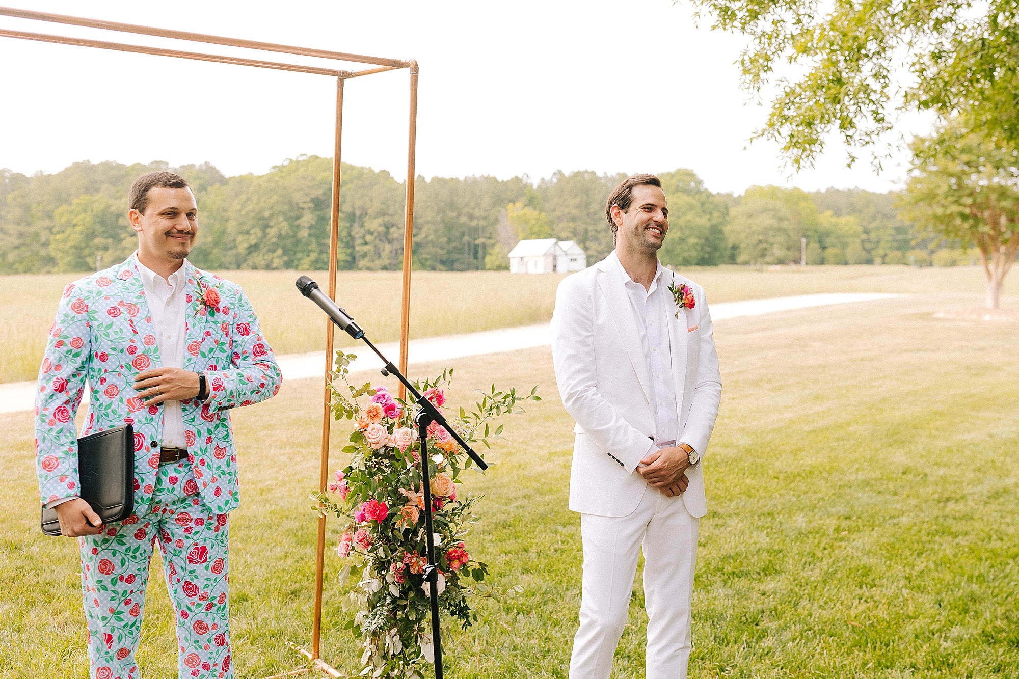 groom watches bride walk down aisle during colorful wedding ceremony at The Meadows Raleigh