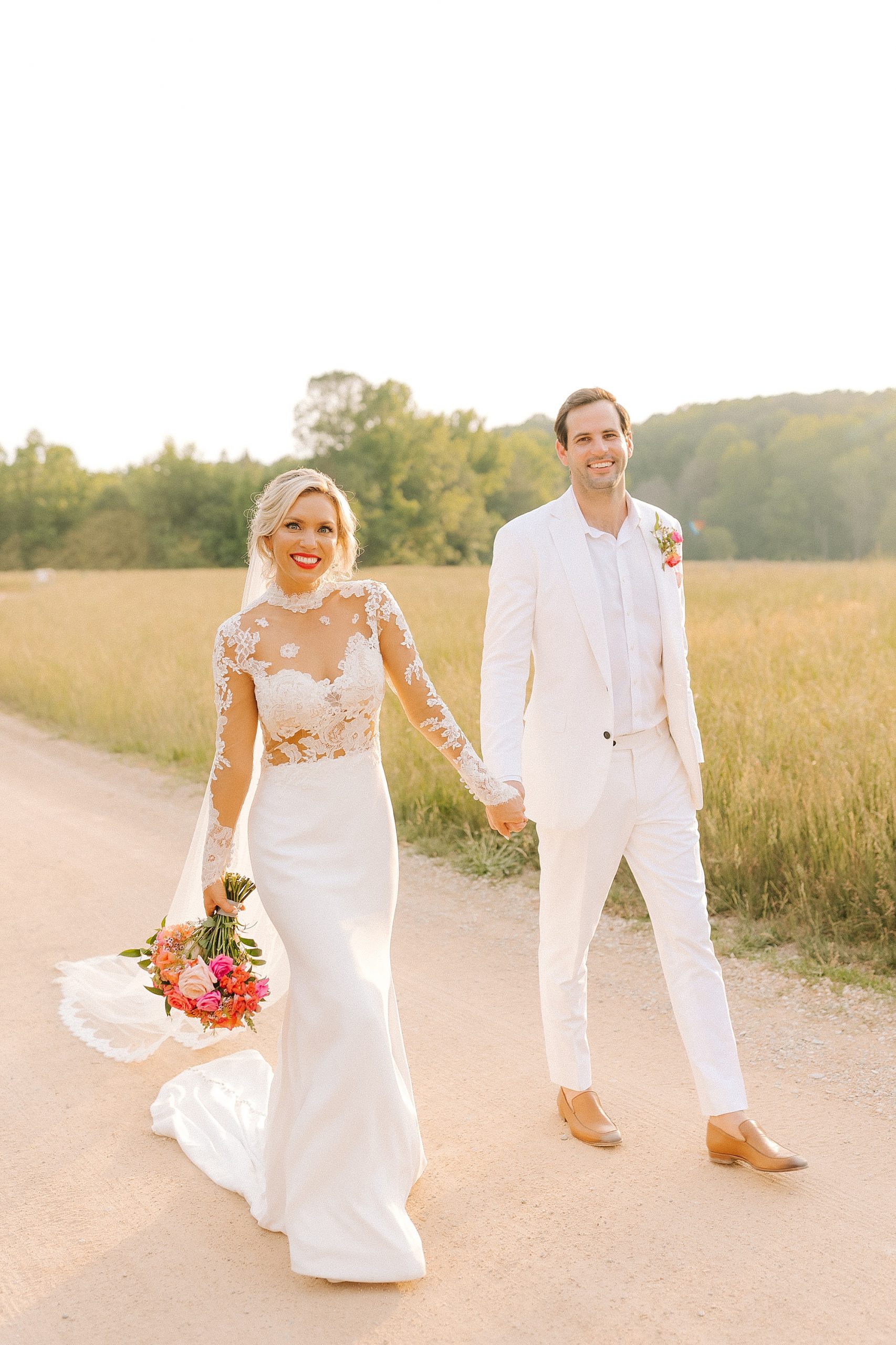 bride and groom hold hands walking on pathway