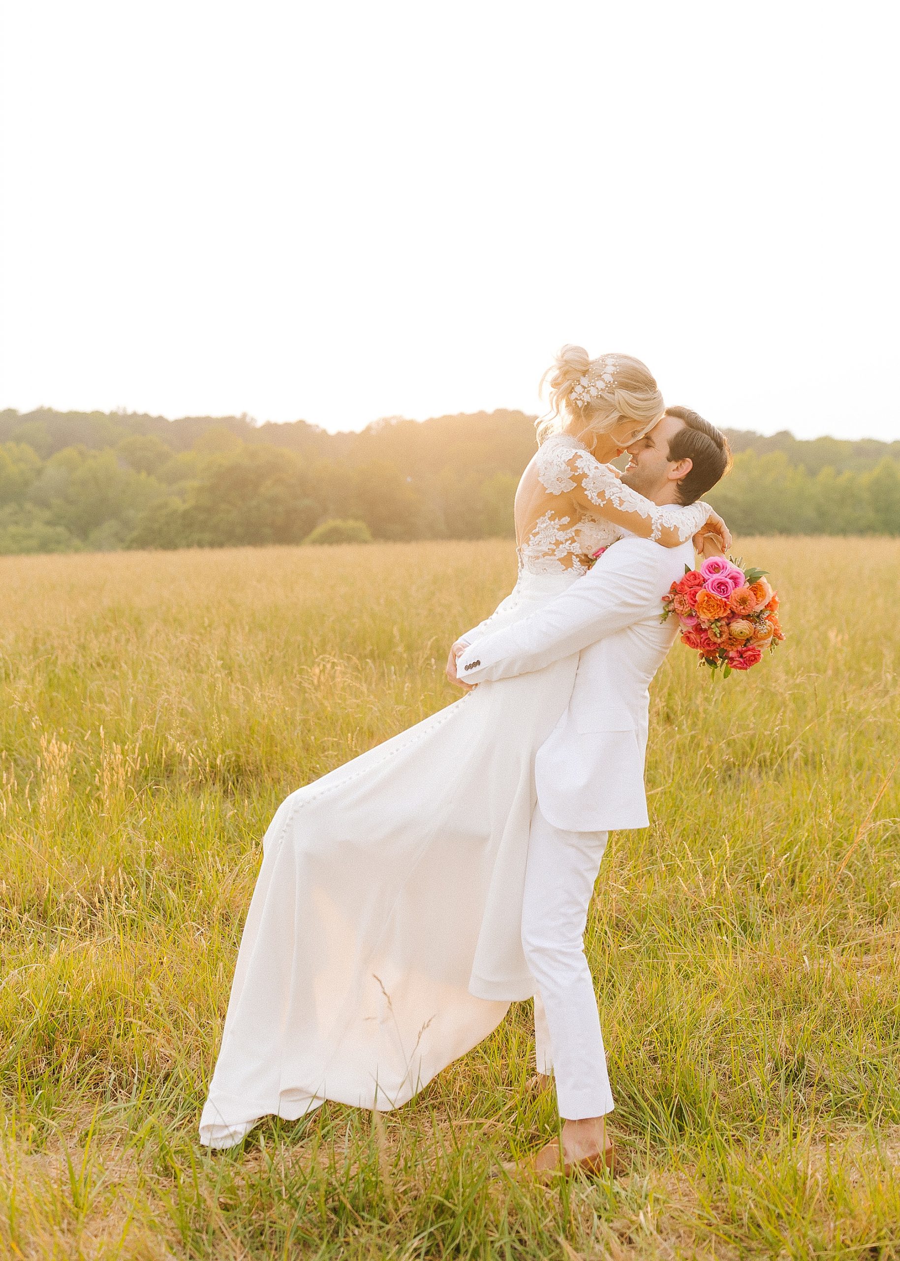 groom lifts bride during portraits at sunset in The Meadows Raleigh