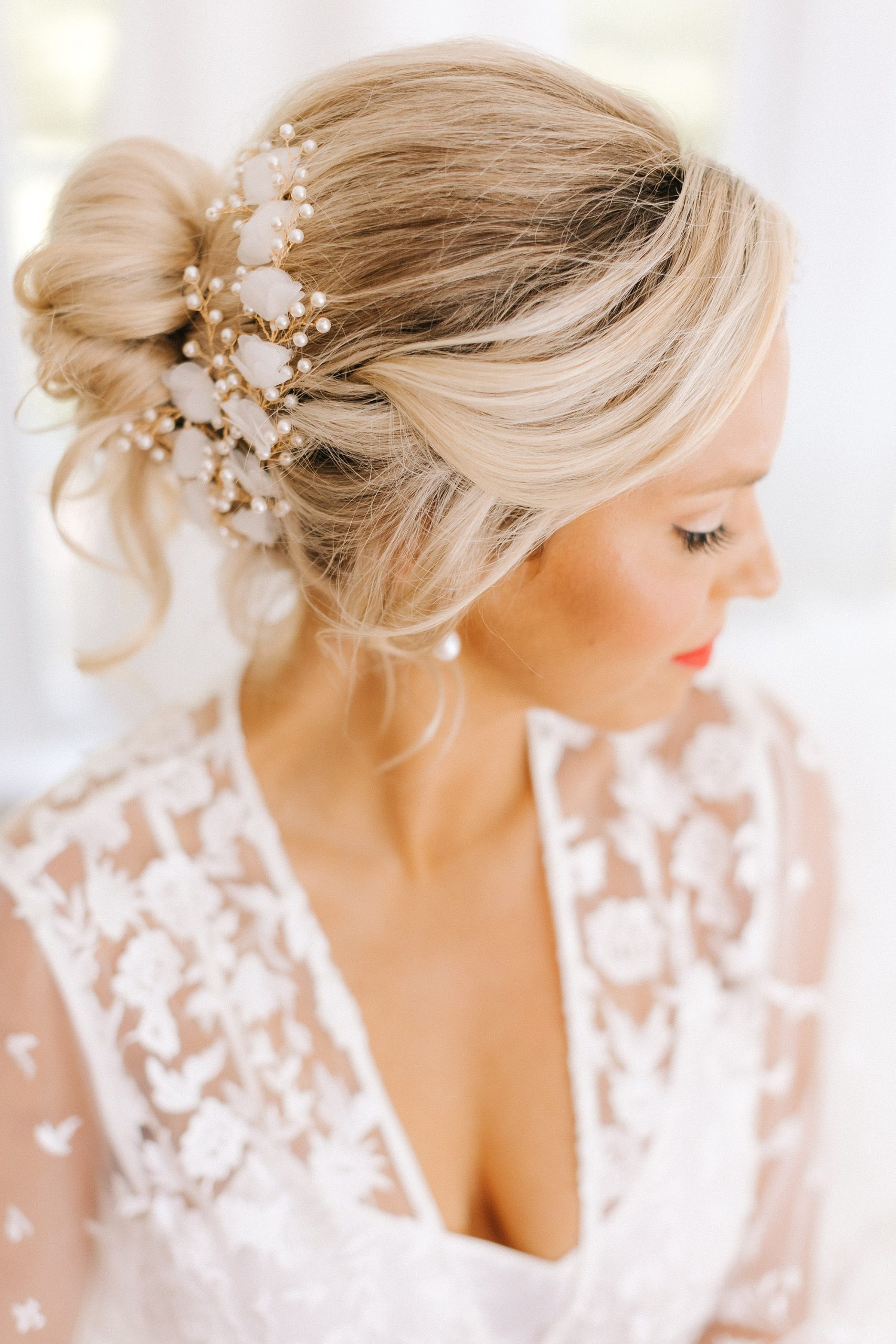 bride looks over shoulder with gold and white hairpiece