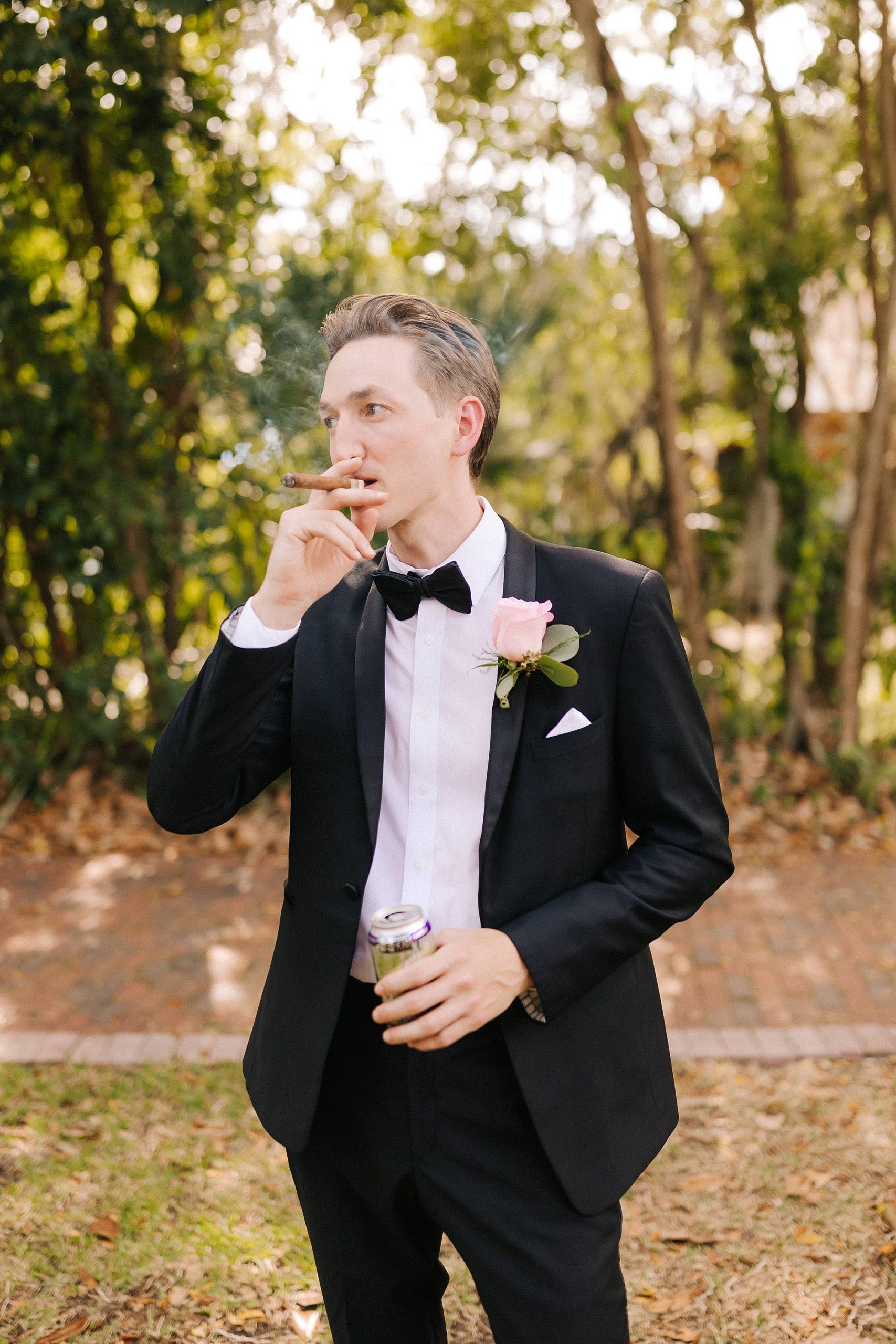 groom smokes cigar during Gainesville FL wedding day