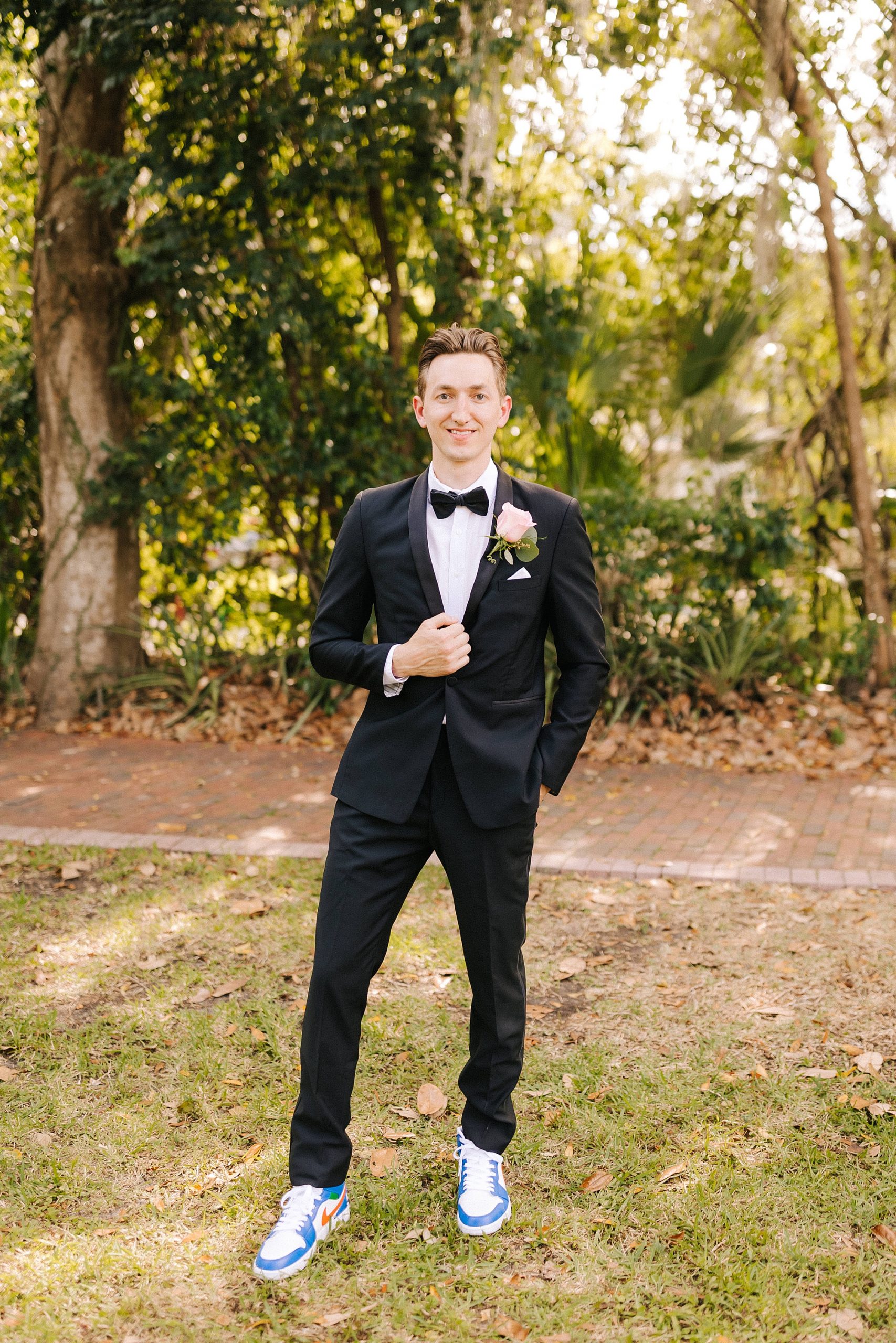 groom poses with classic black tux
