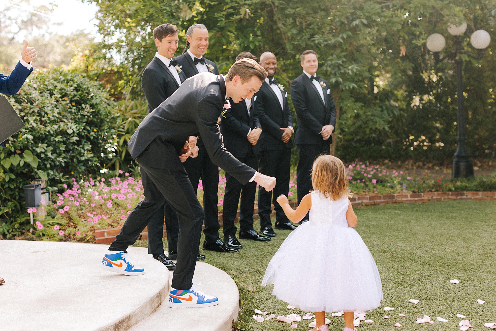 flowers girl gives groom a first bump during outdoor wedding ceremony in Florida
