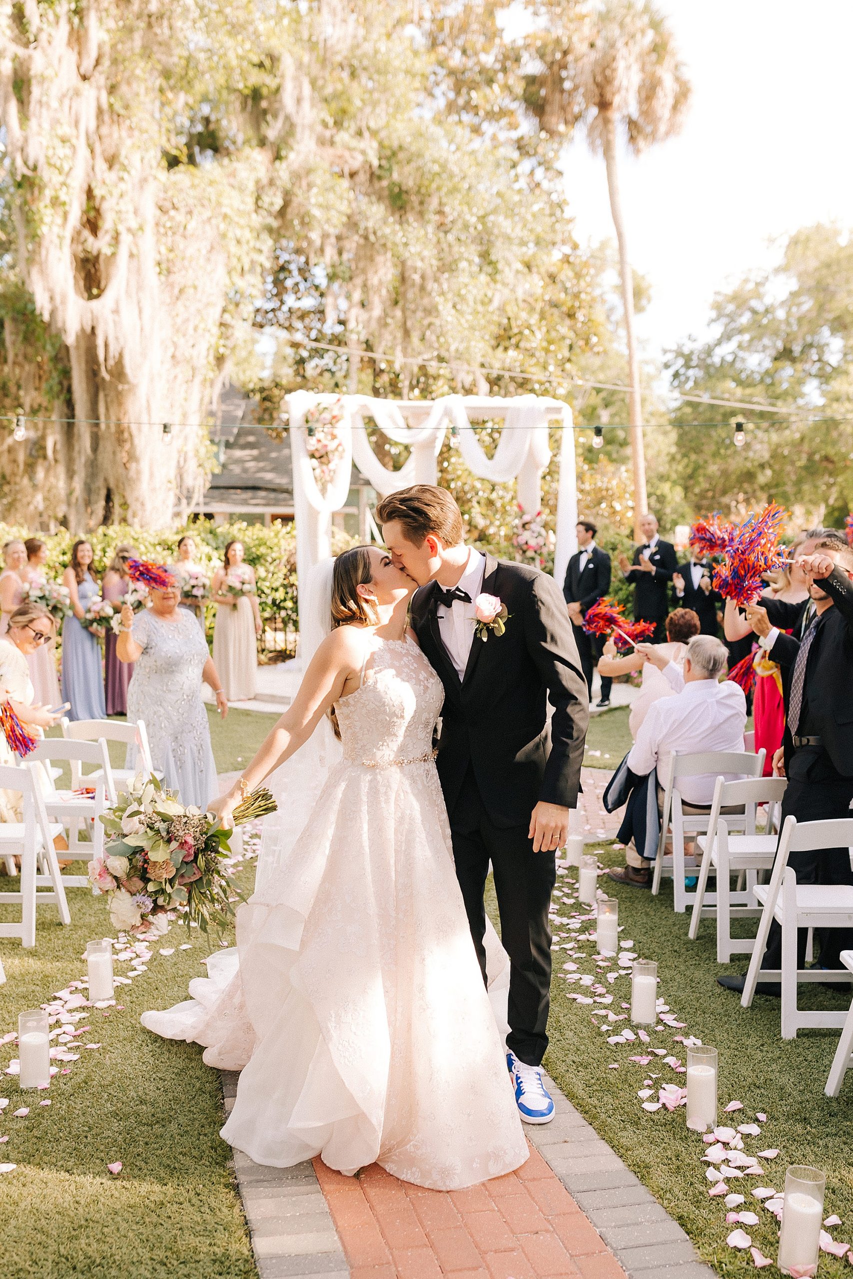 bride and groom kiss at end of aisle after outdoor wedding ceremony in Florida