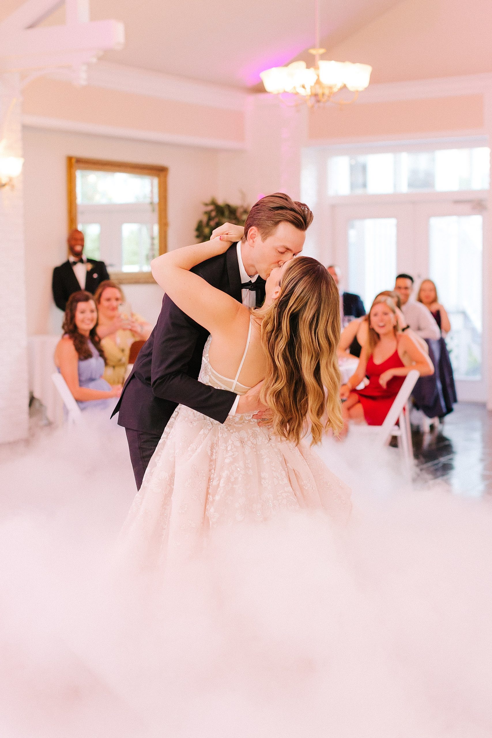 bride and groom kiss during first dance with smoke at FL wedding reception