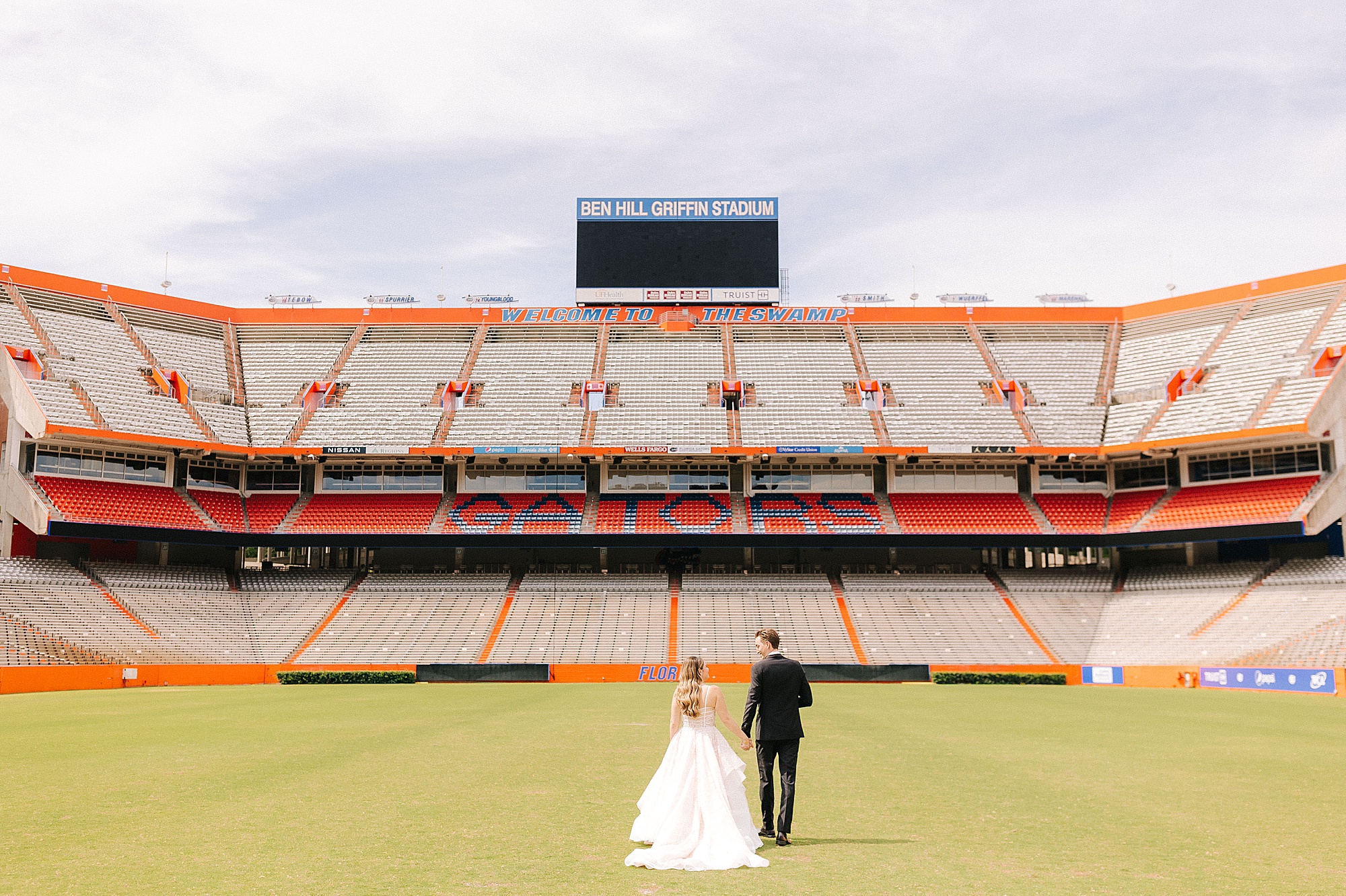 newlyweds walk through stadium at University of Florida
