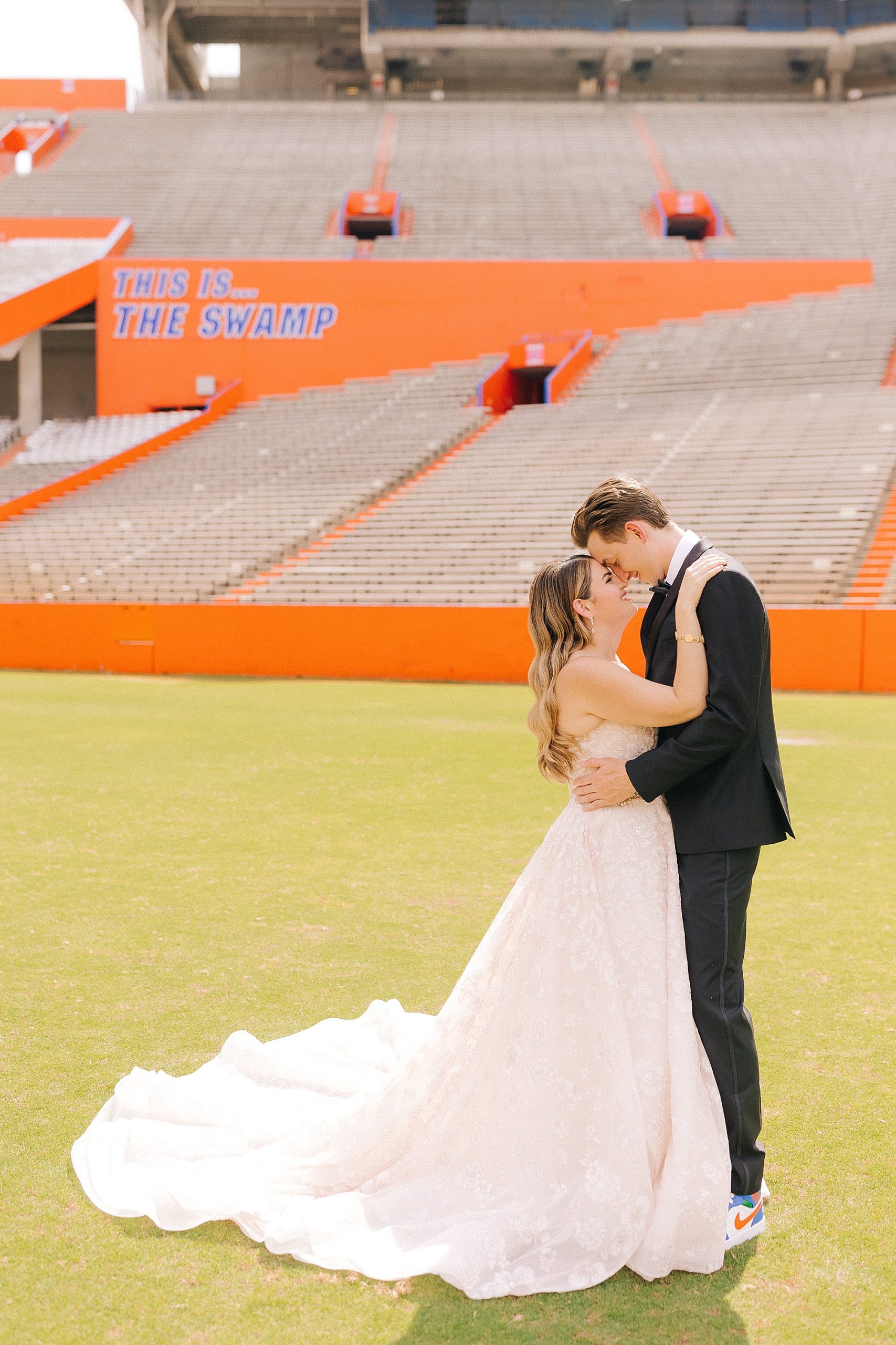 newlyweds stand nose to nose on football field at University of Florida