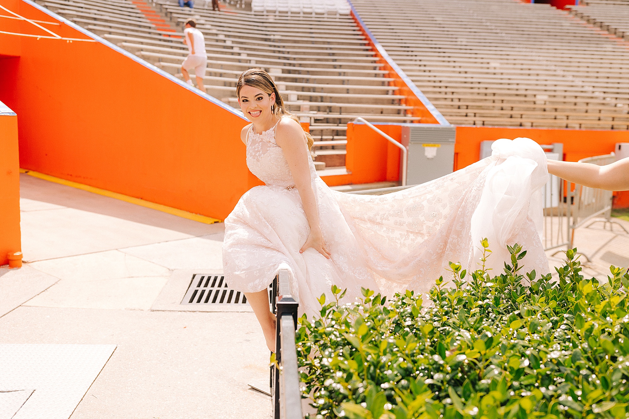 bride climbs over railing at University of Florida