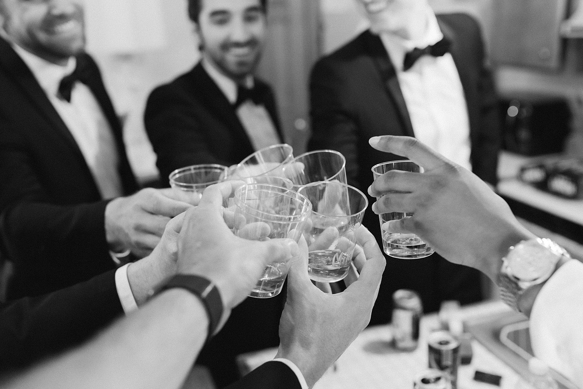 groom and groomsmen toast during wedding prep 