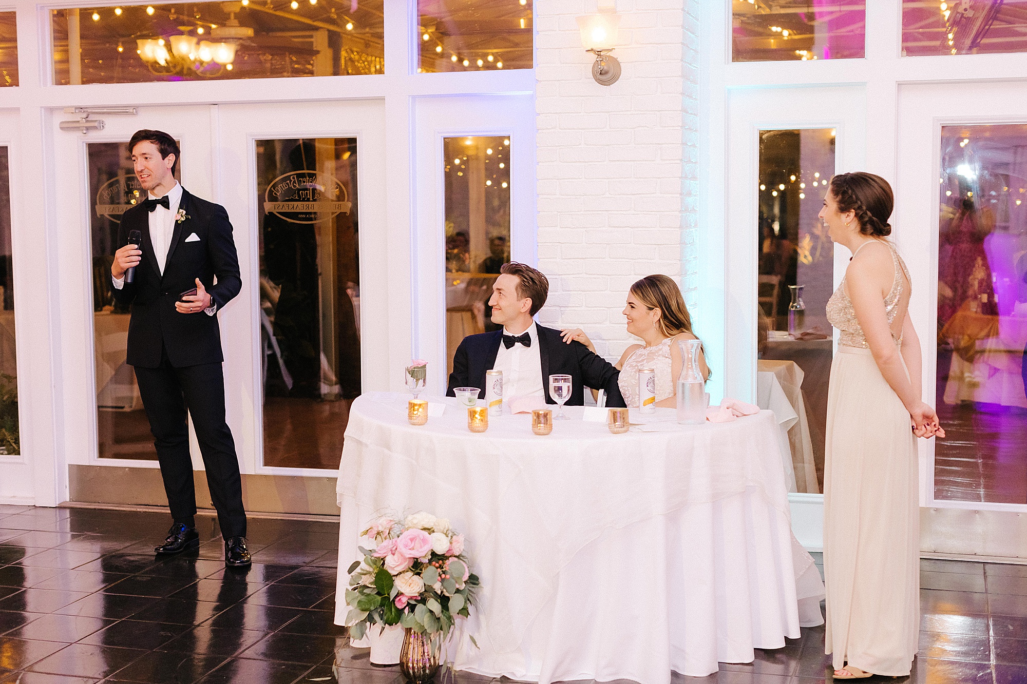 bride and groom listen to toasts during FL wedding reception