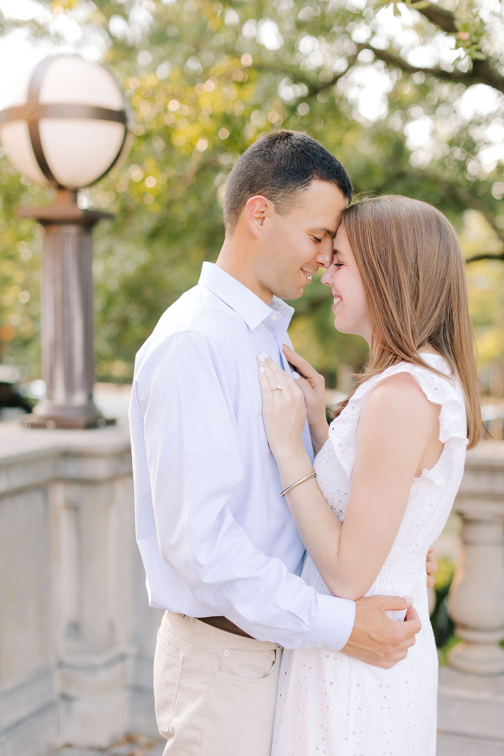 bride and groom stand nose to nose on patio at UNC Chapel Hill