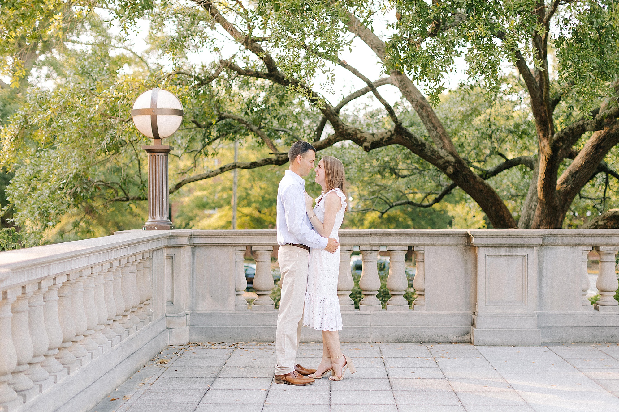 engaged couple stands nose to nose on patio at UNC Chapel Hill