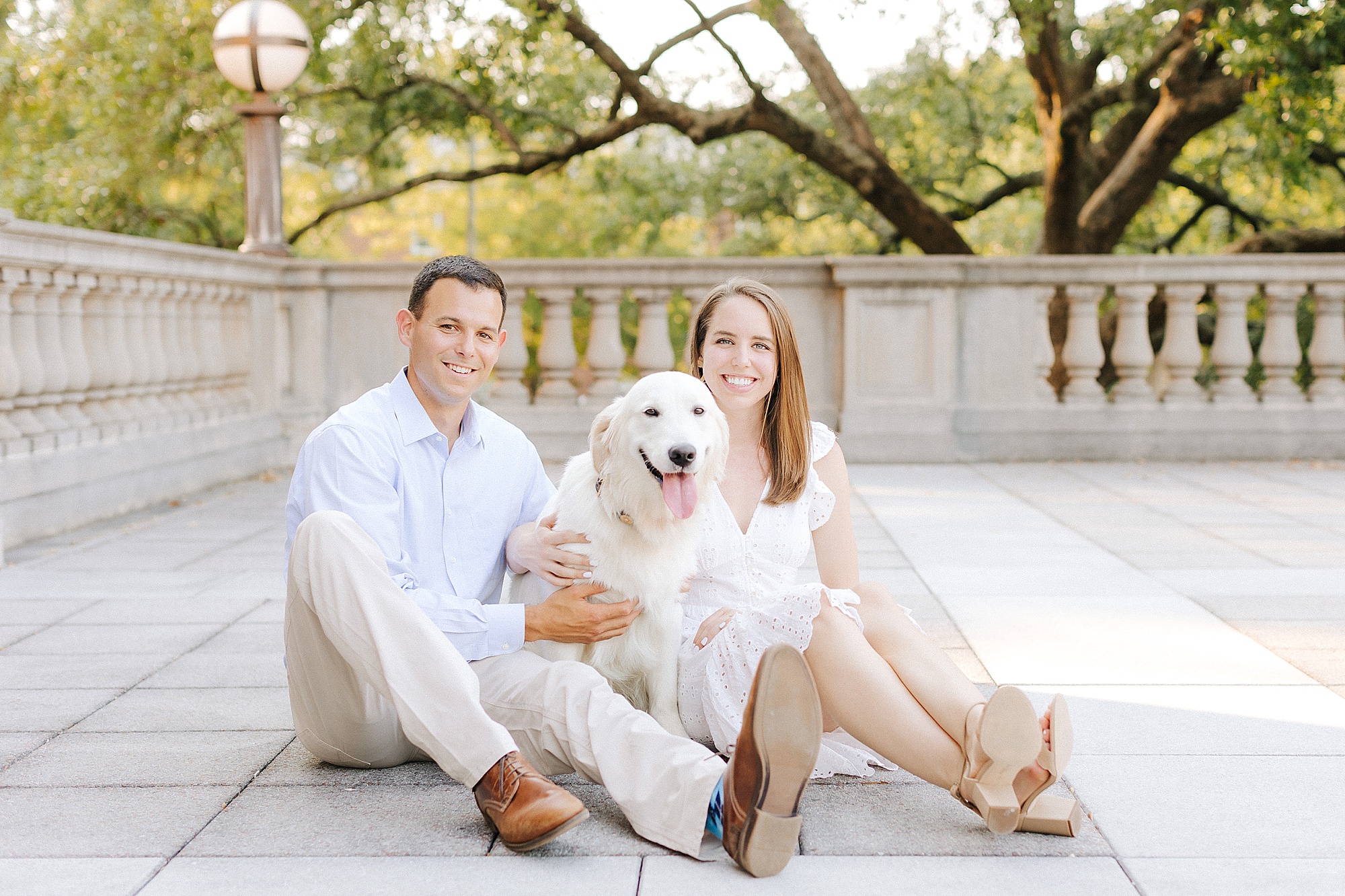 engaged couple sits on patio at UNC Chapel Hill with white dog