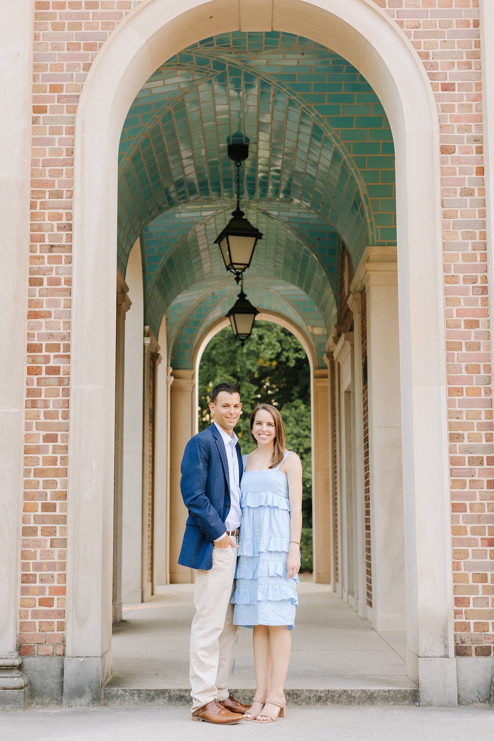 couple poses in walkway at UNC Chapel Hill